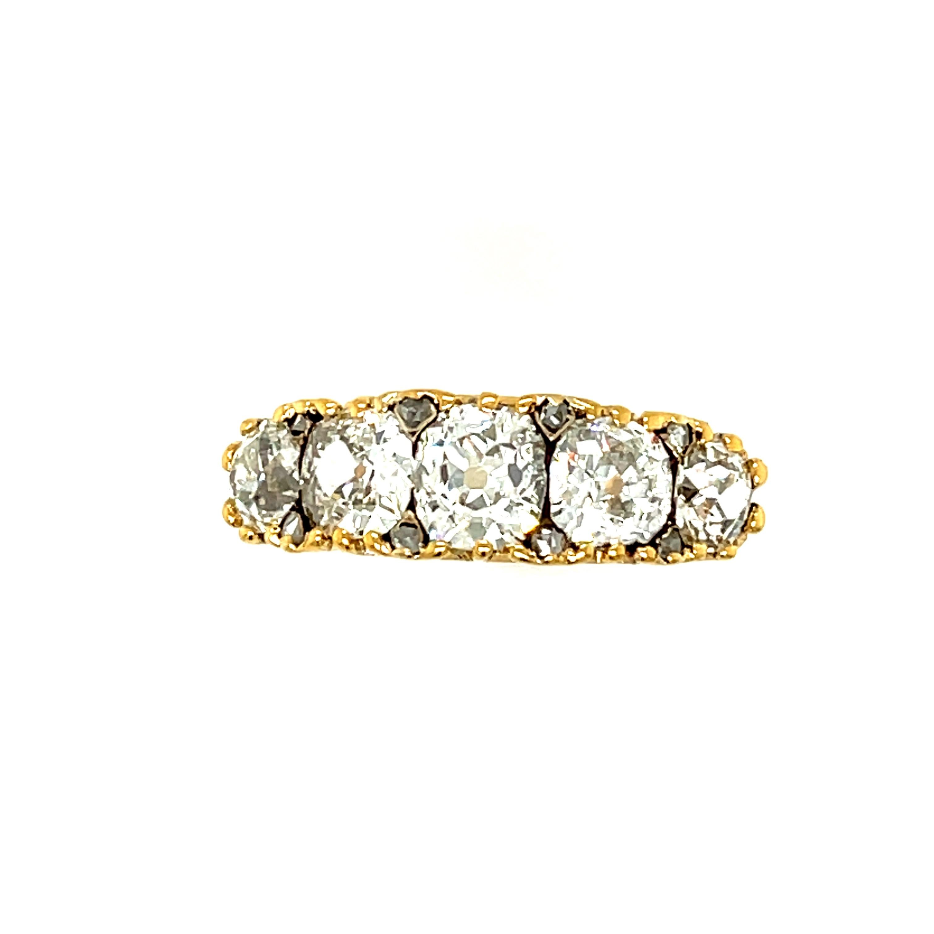 An antique Victorian 18k gold five stone old mine diamond half hoop ring, circa 1870. The ring is set with chunky old cut stones that are not round but cushiony in shape. This creates the look of the stones being particularly close together without