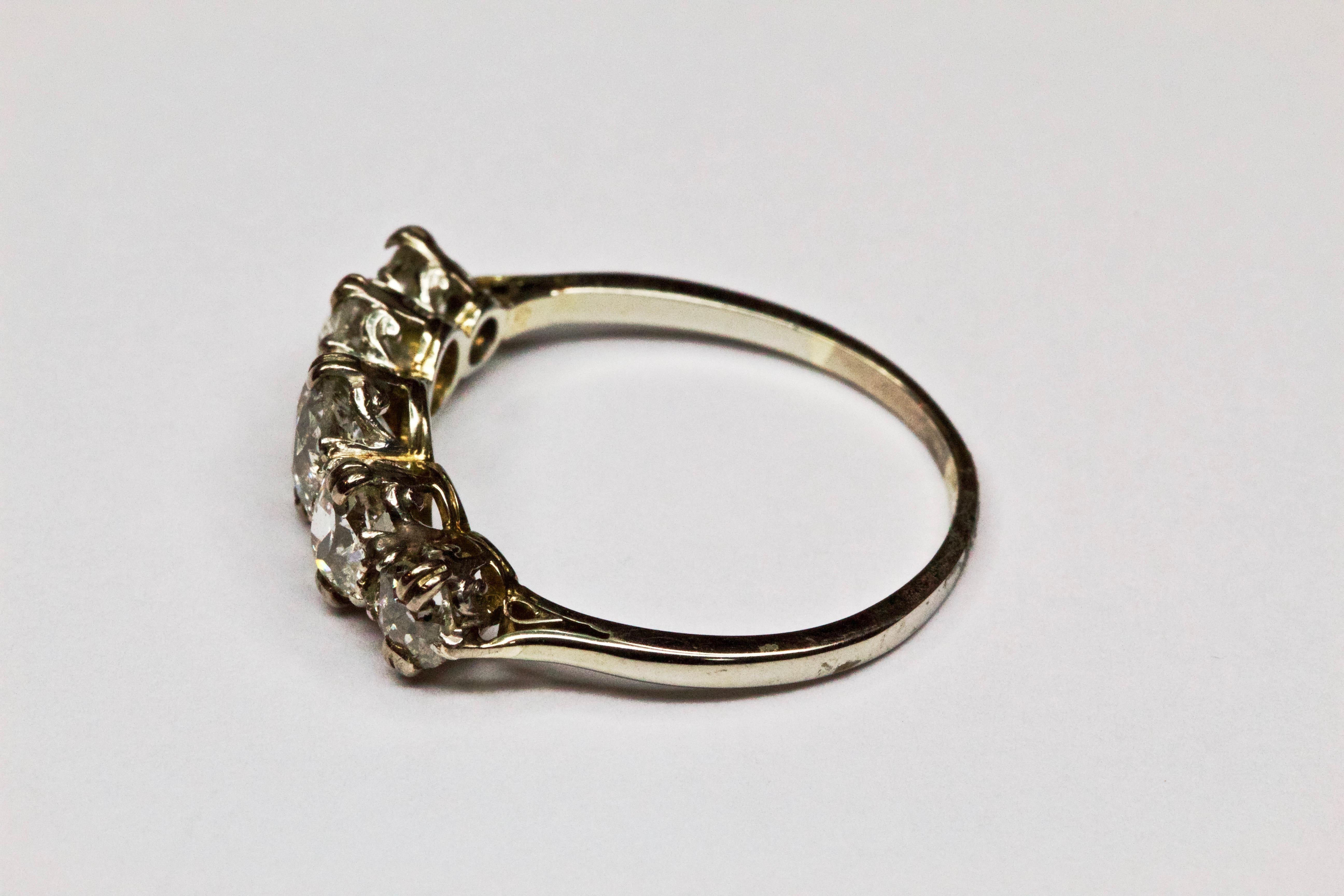 This antique Victorian diamond and platinum ring was handcrafted in England around 1890. This glimmering English ring features five Old European cut diamonds, totalling approximately 1.46 carats. These round precious stones are lined in a row and