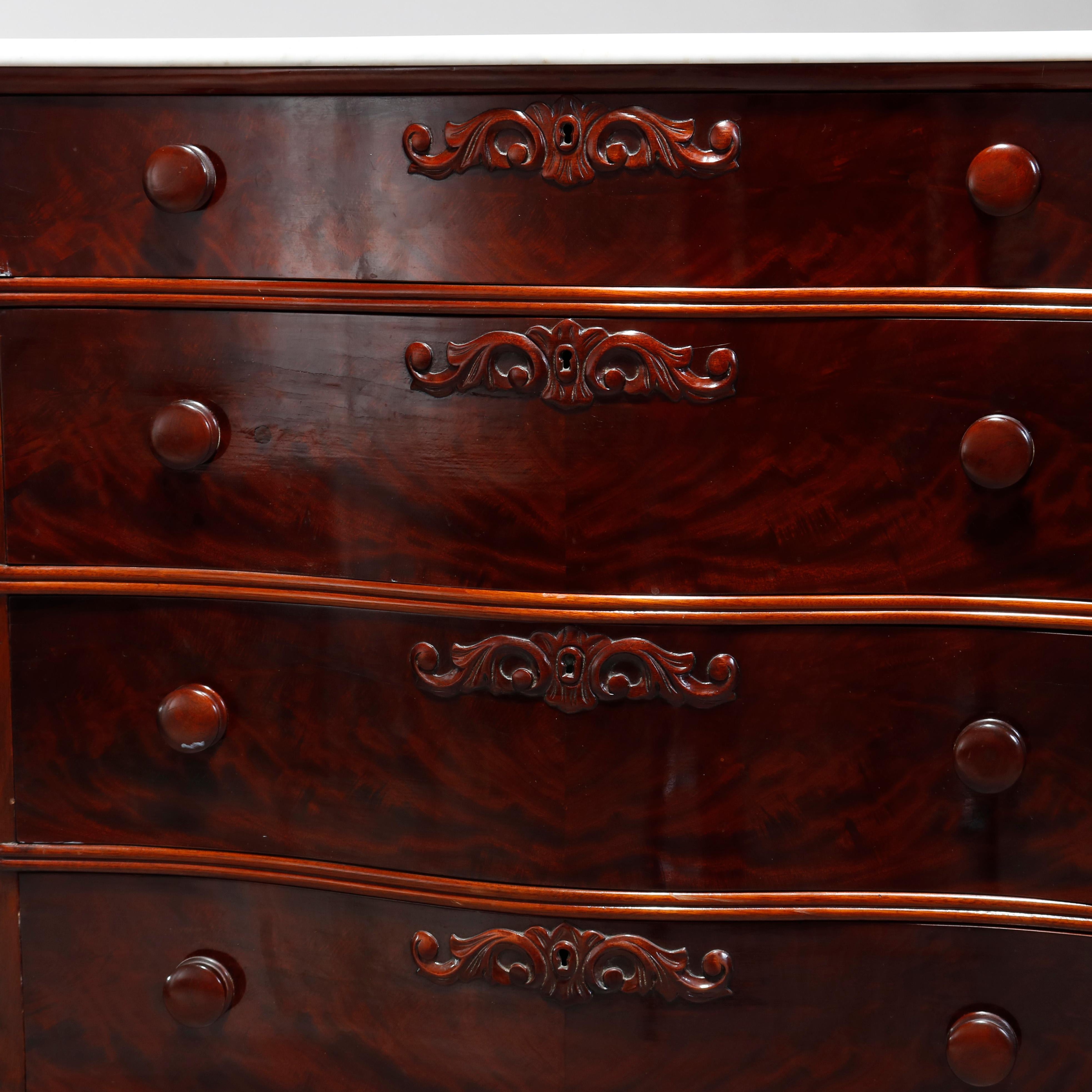 An antique Victorian chest of drawers offers flame mahogany construction with shaped and beveled marble top surmounting swell front case having four bookmatched drawers with foliate carved elements and shaped skirt, raised on bracket feet,