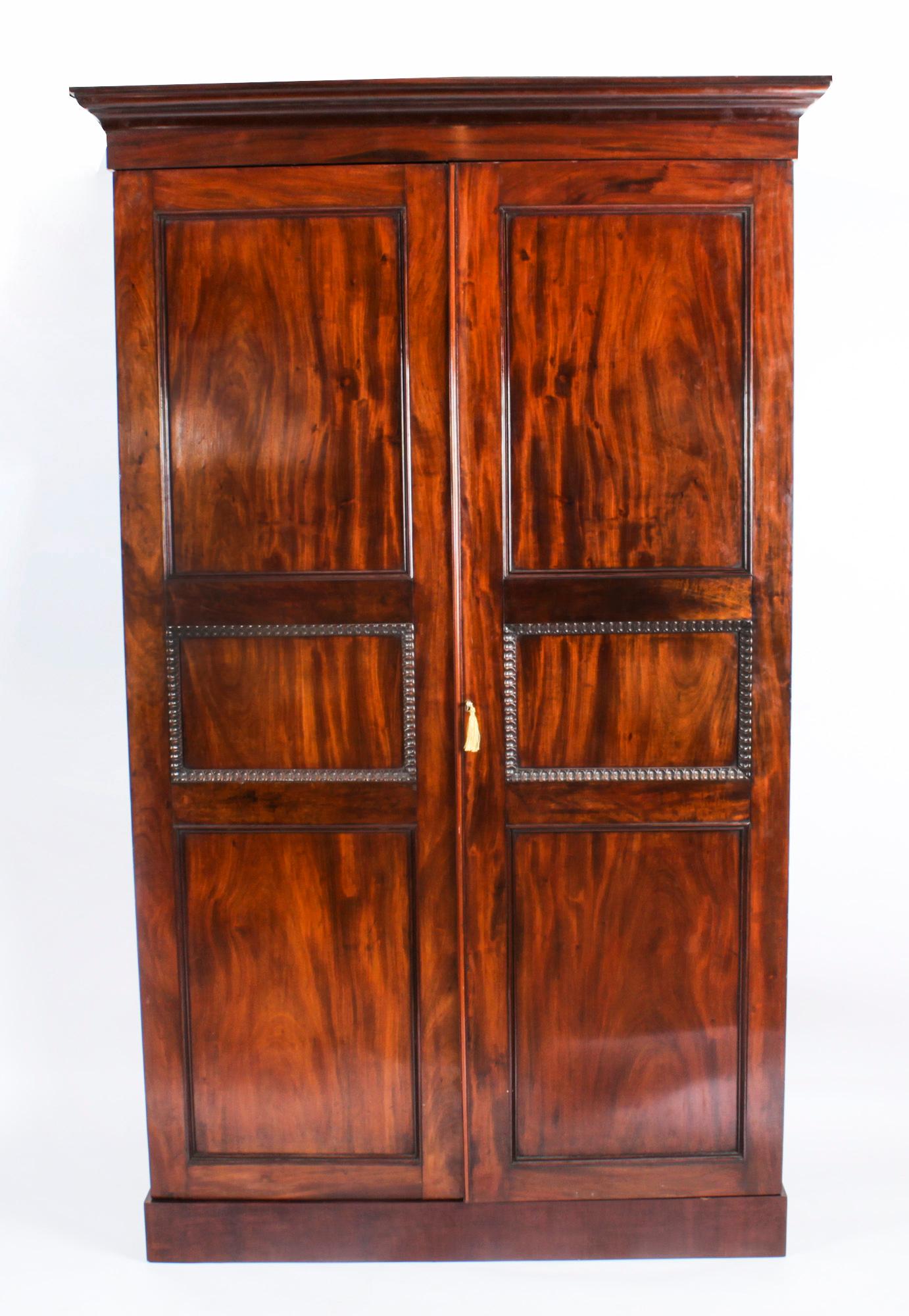 This is an impressive and elegant antique English Victorian flame mahogany wardrobe, circa 1880 in date.
 
This wonderful tall two door wardrobe features an exquisite flared cornice above highly attractive and beautifully figured flame mahogany