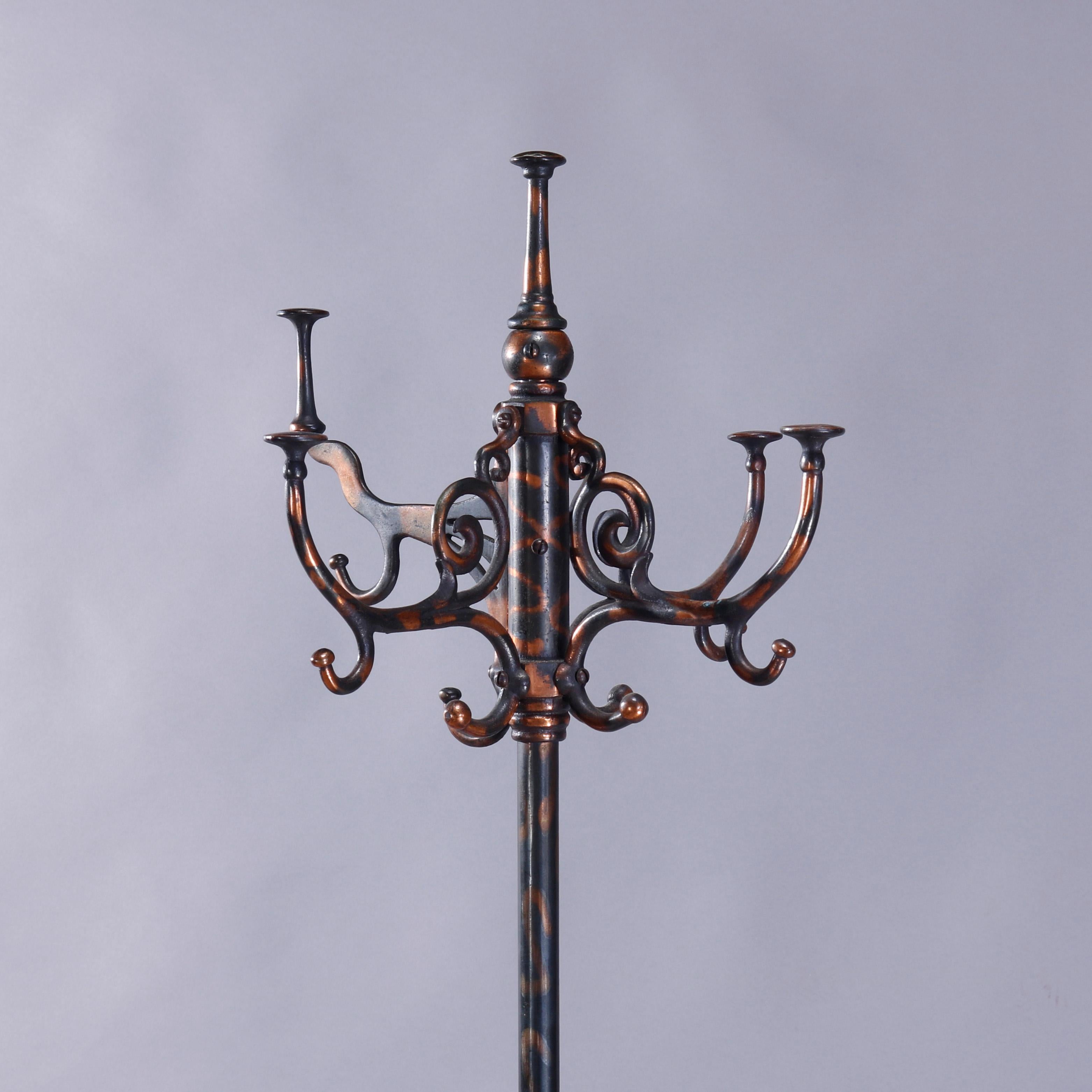 An antique Victorian coat tree offers flashed Copper and wrought iron construction with upper coat hooks having scrolled corbels raised on central column with umbrella receivers over drip tray and terminating in cabriole legs, c1900

Measures: 70