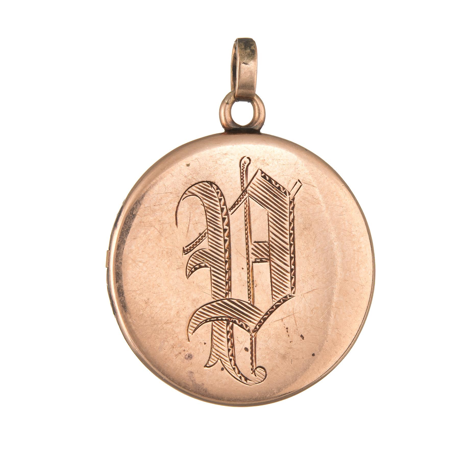 Elegant and finely detailed antique Victorian round locket (circa 1880s to 1900s) crafted in 10k rose gold. 

Thirteen old mine cut diamonds total an estimated 0.25 carats (estimated at I-J color and SI2-I1 clarity). 

The romantic locket features a