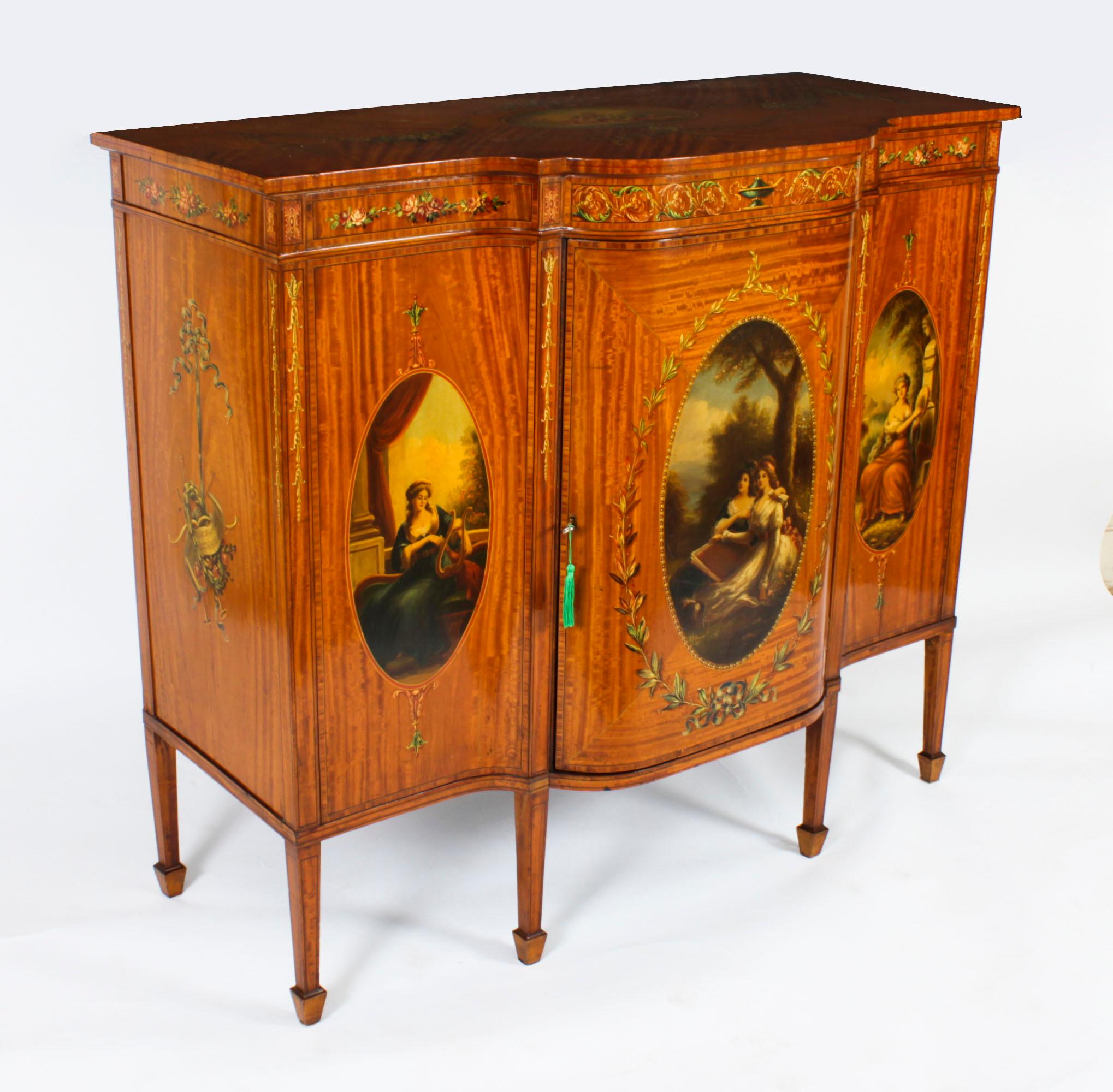 This is a truly stunning English late Victorian hand-painted and inlaid shaped satin wood sideboard, circa 1880 in date.

This splendid crossbanded cabinet is made of the finest quality satin wood with a striking flame effect.
 
The top features a