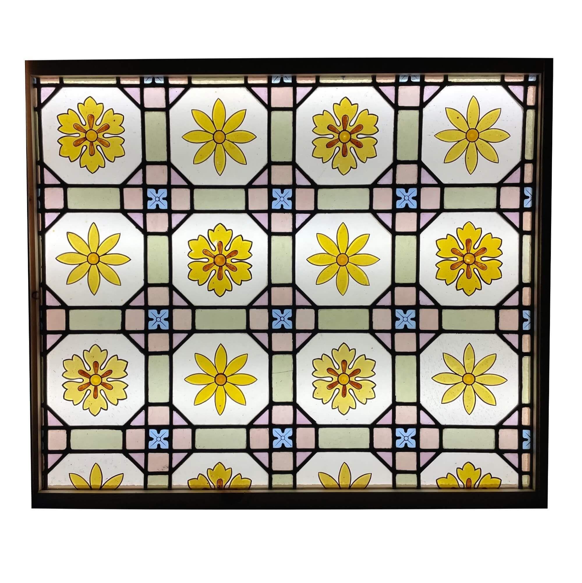 An antique late Victorian floral patterned stained glass window, dating to circa 1890. This late 19th century piece showcases vibrant daisies, accompanied by small blue flowers, in a floral grid.

This beautiful panel is over 100 years old and would
