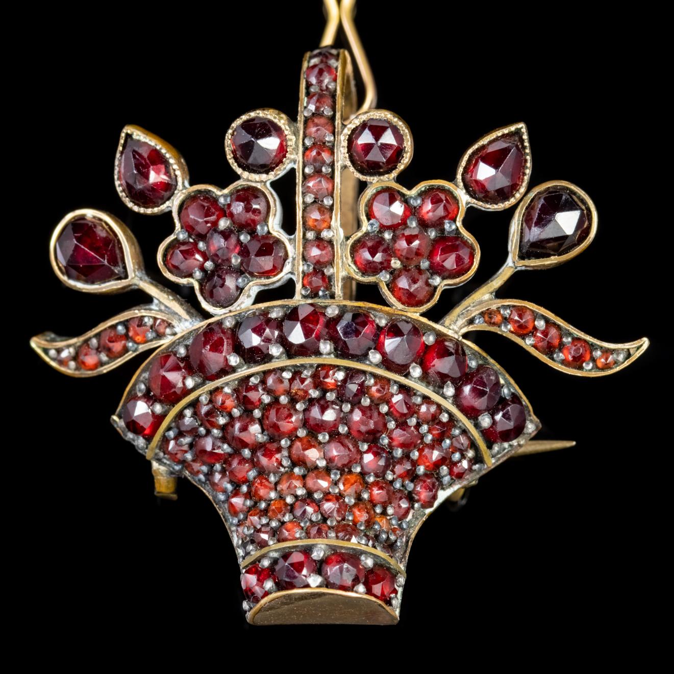 This wonderful antique Victorian pendant brooch depicts a lovely basket of flowers which is decorated with deep red Garnets which have been cut to fit the pendants unique design.  

The Garnet has been adored throughout history for its blazing red