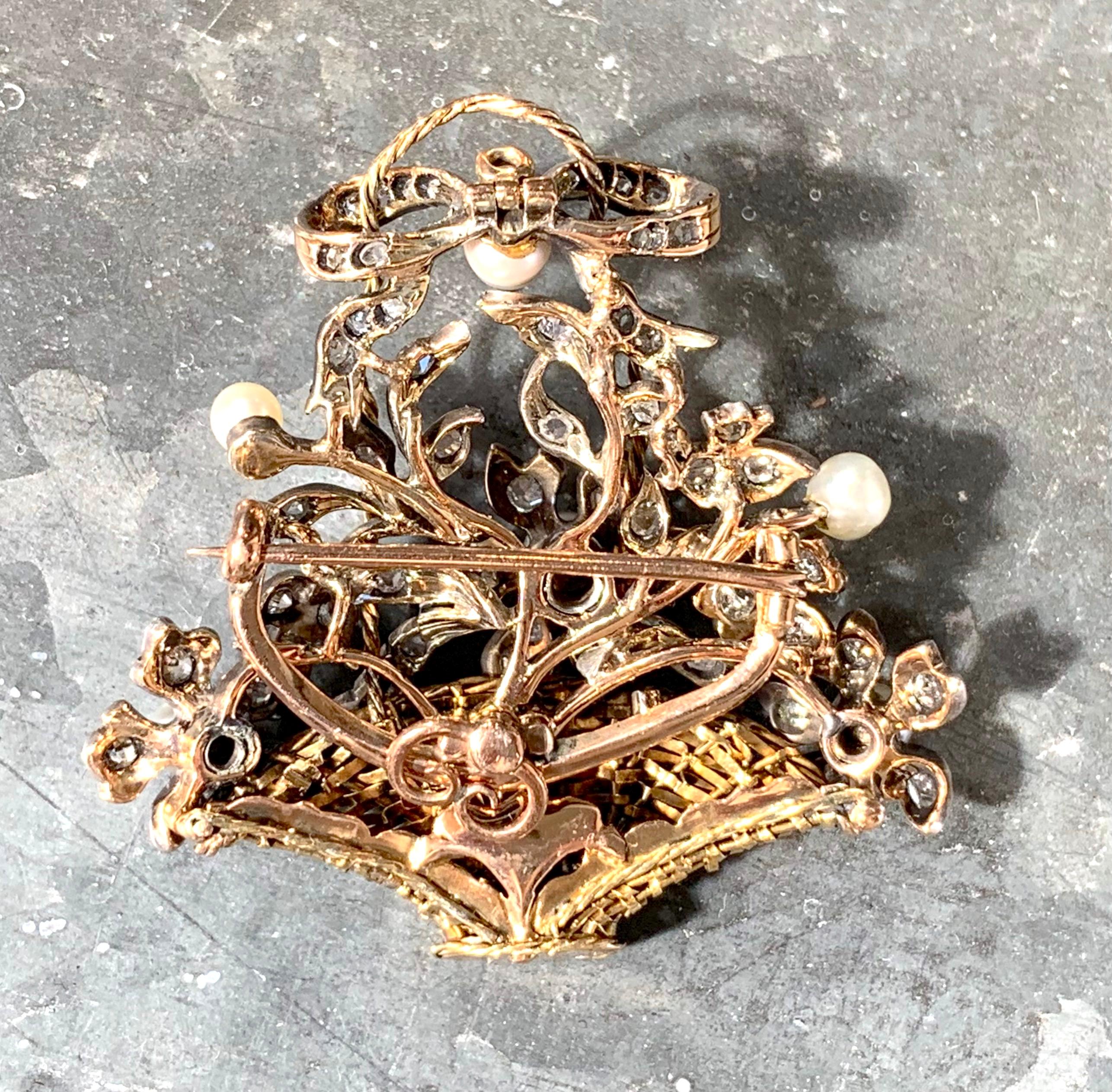 Diese elegante Brosche ist in Form einer Anordnung von Diamanten gestaltet  und mit Perlen besetzte Blumen in einem geflochtenen goldenen Stielkorb.