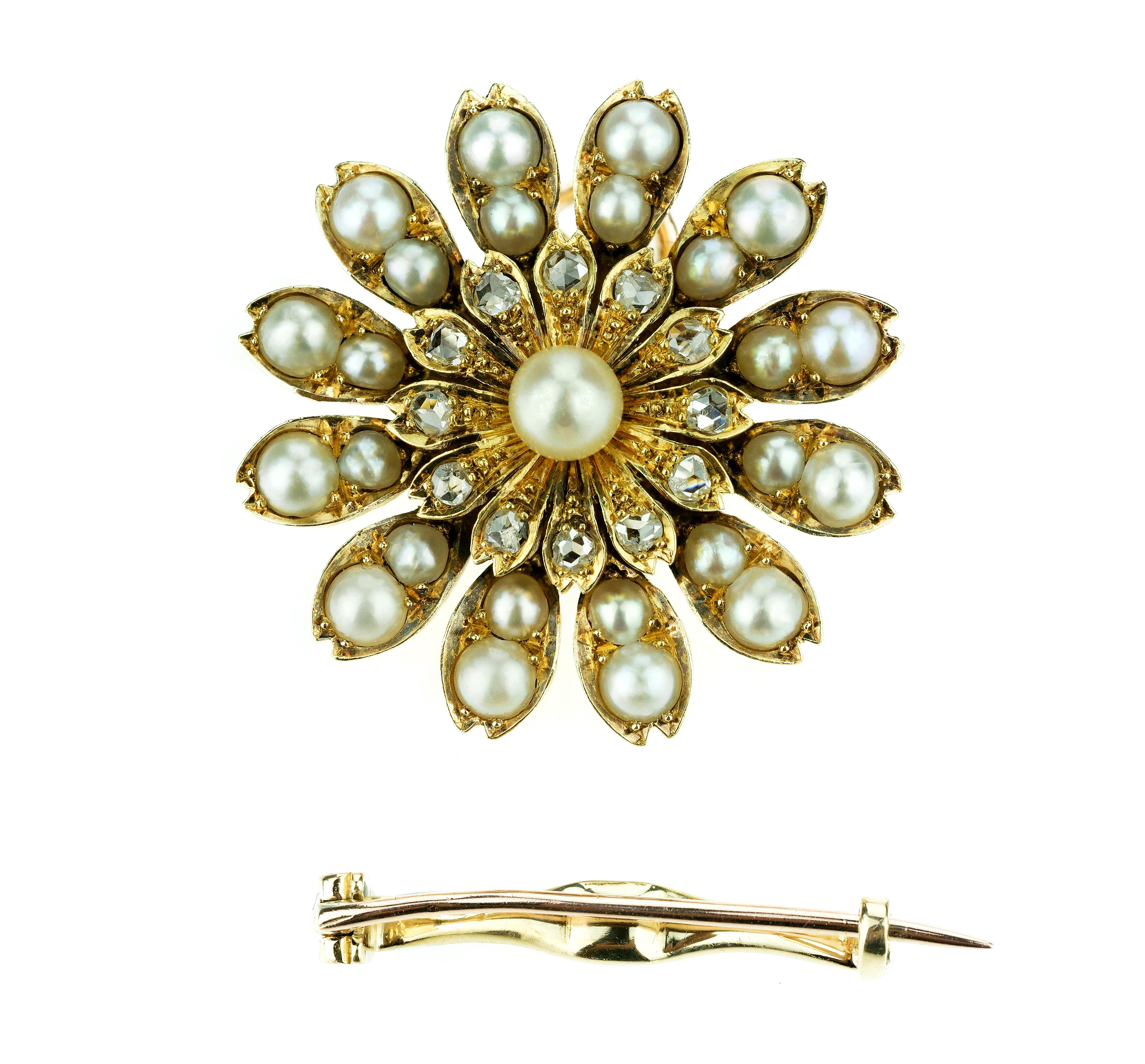 A fine Victorian eighteen carat gold, diamond and natural saltwater pearl pendant with a detachable brooch fitting. Designed as a flower head, the central pearl is bordered by rose cut diamonds, with a further double row of pearls creating the