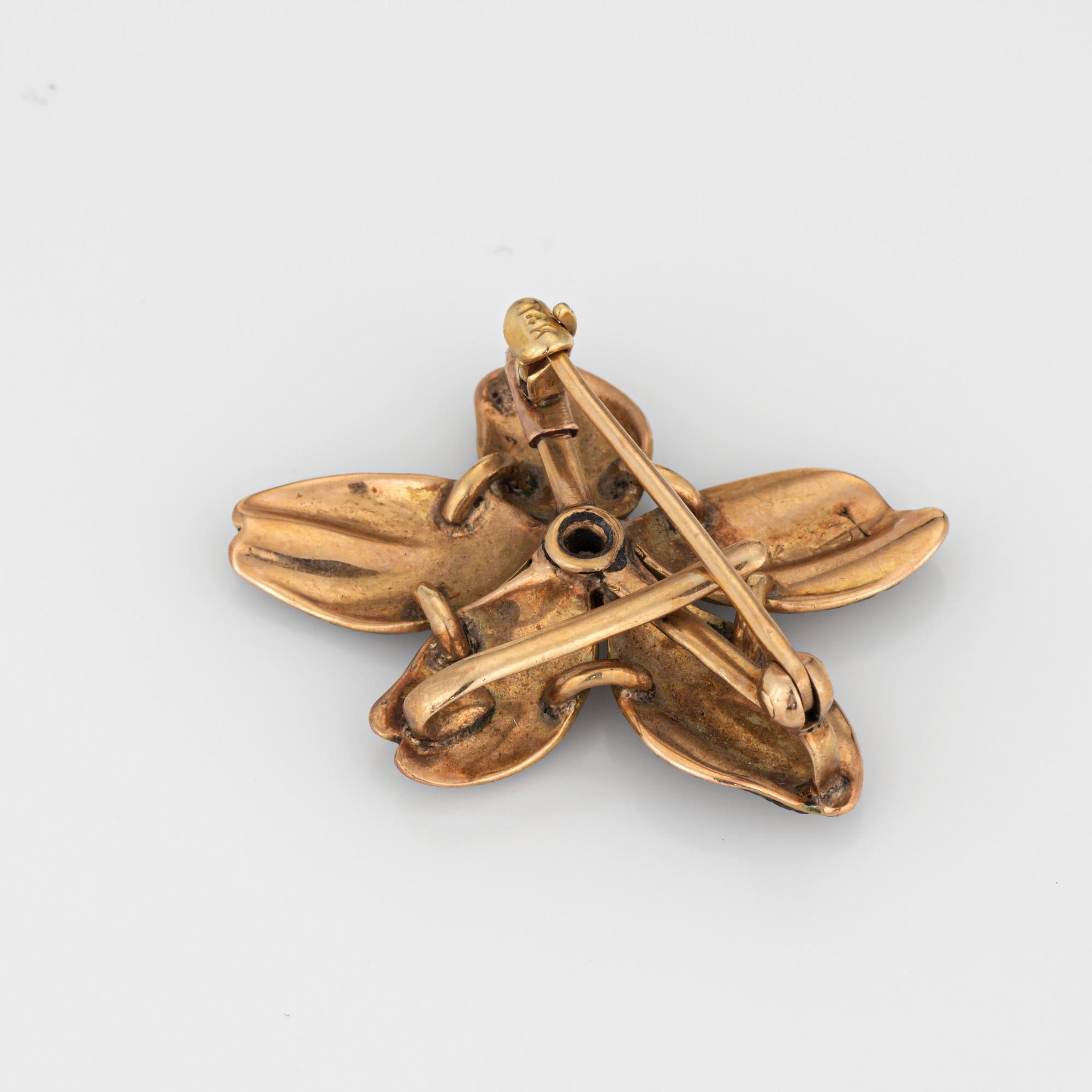 Finely detailed antique Victorian black enamel diamond pendant/brooch crafted in 14k yellow gold (circa 1880s to 1900s).

One estimated 0.25 carat old mine cut diamond is set into the flower (estimated at I-J color and SI2-I1 clarity). The striking