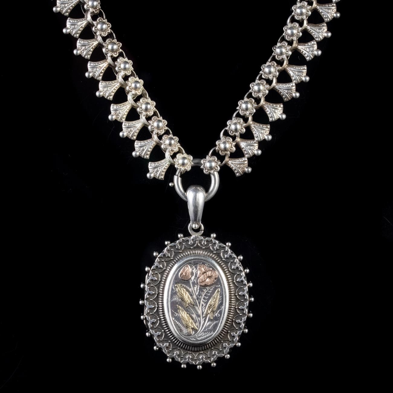 This magnificent Antique Victorian collar and locket has been masterfully commissioned in Sterling Silver. The collar boasts intricate and ornate links which finish at a ring clasp to hold the locket. The locket features engravings of forget me nots