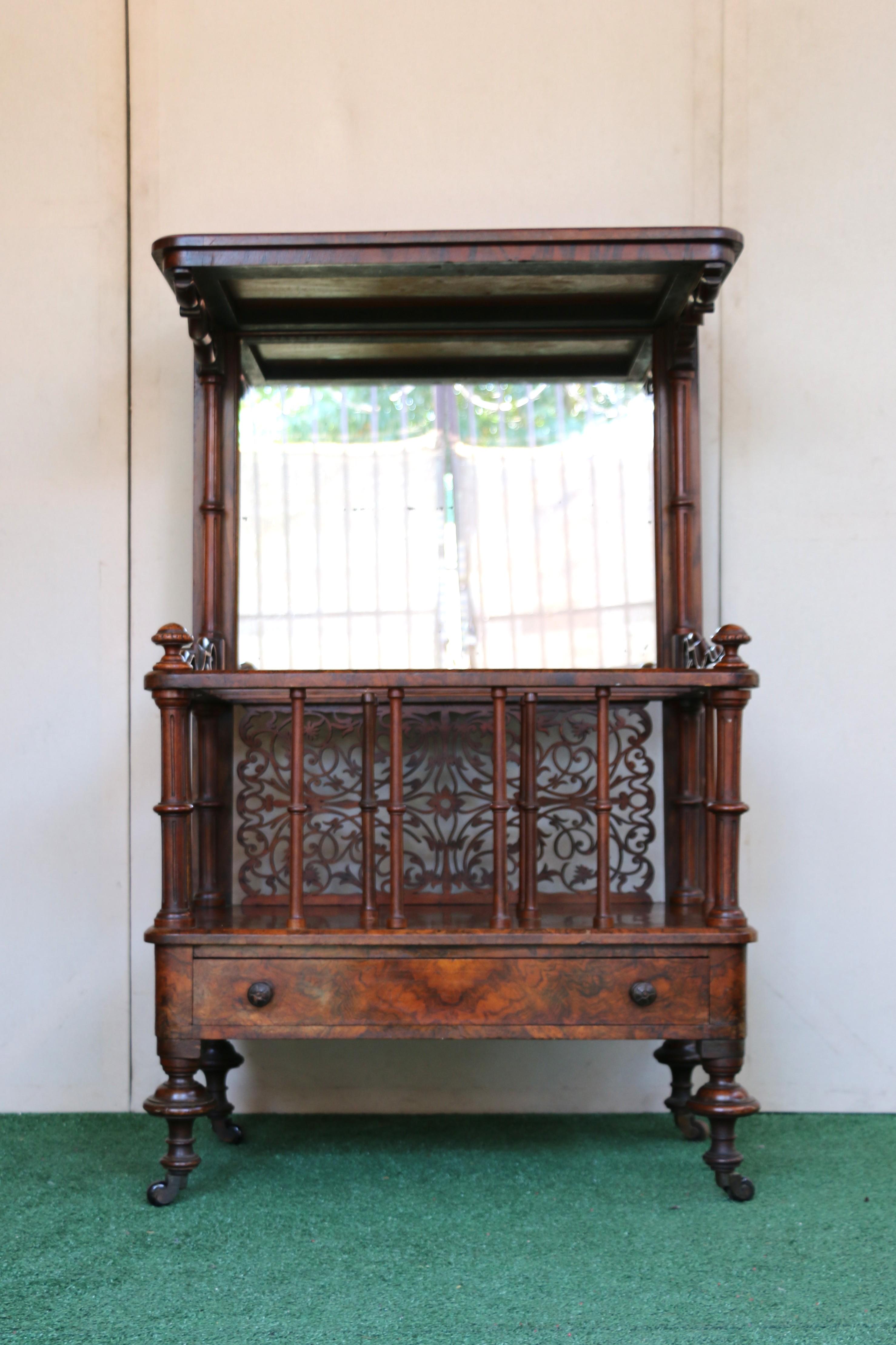 Victorian Canterbury Whatnot, a type of furniture that originated in the late 18th century, with its popularity peaking in the Victorian era. Made of walnut with turned columns and feet ending in wood castors. It also has a decorative pierced brass