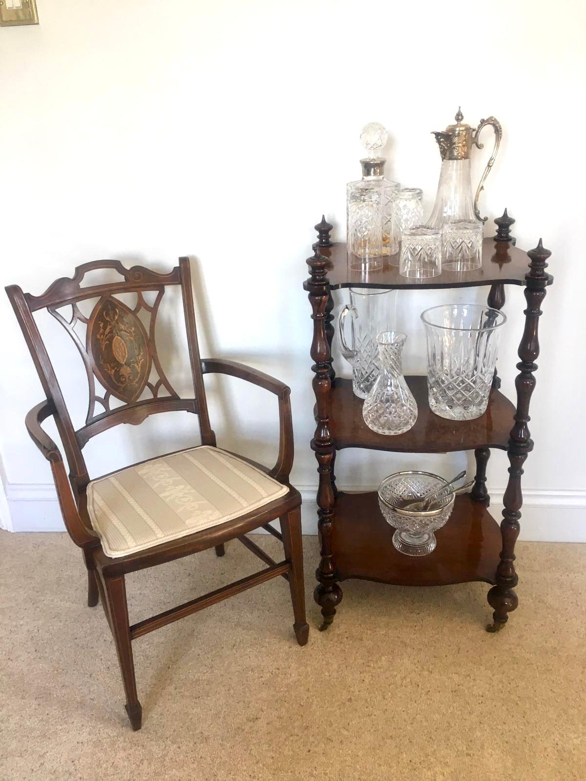 Antique Victorian freestanding rosewood whatnot having three serpentine shaped rosewood shelves supported by eight solid rosewood turned columns and four original turned finials. It stands on turned feet with original brass cup castors.

An