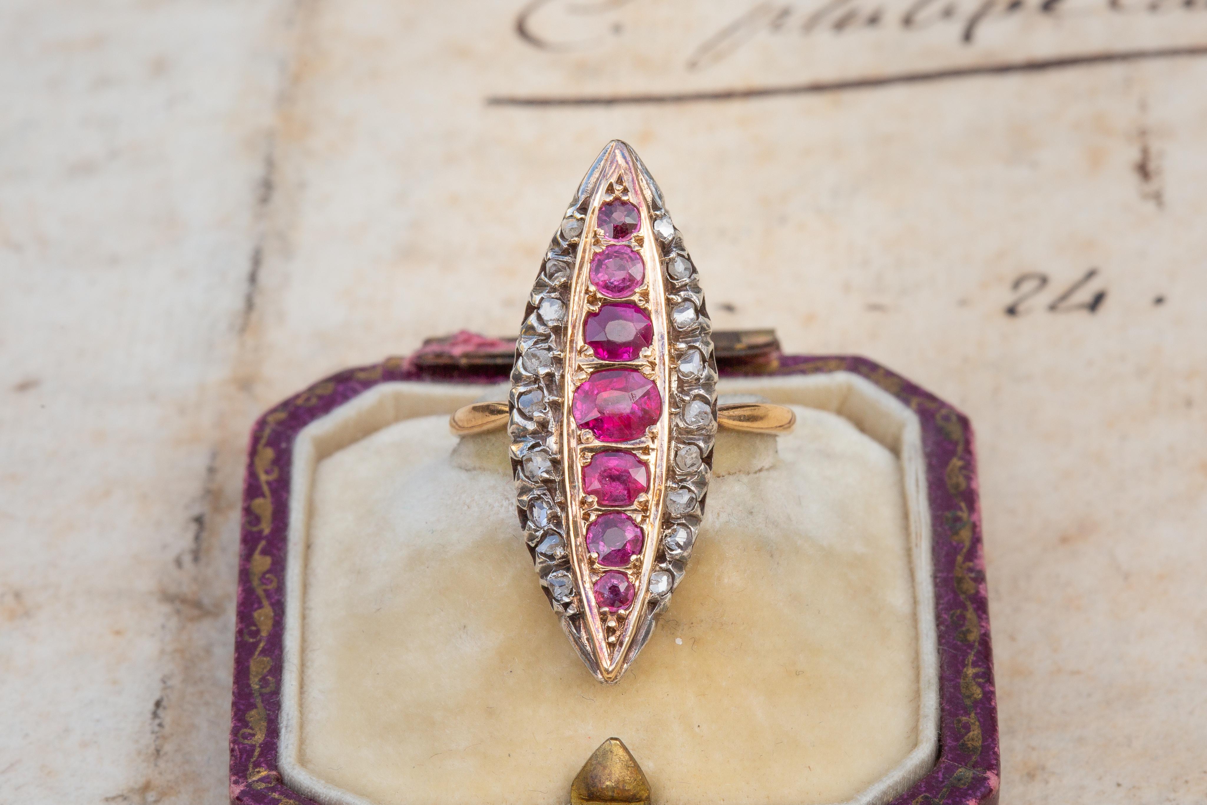 Ein wirklich atemberaubender französischer Ring aus der viktorianischen Ära um 1895. Dieser navetteförmige Cluster besteht aus 18 in Silber gefassten Diamanten im Rosenschliff, die sieben Rubine (insgesamt 1ct) umgeben. Die leuchtend rosafarbenen