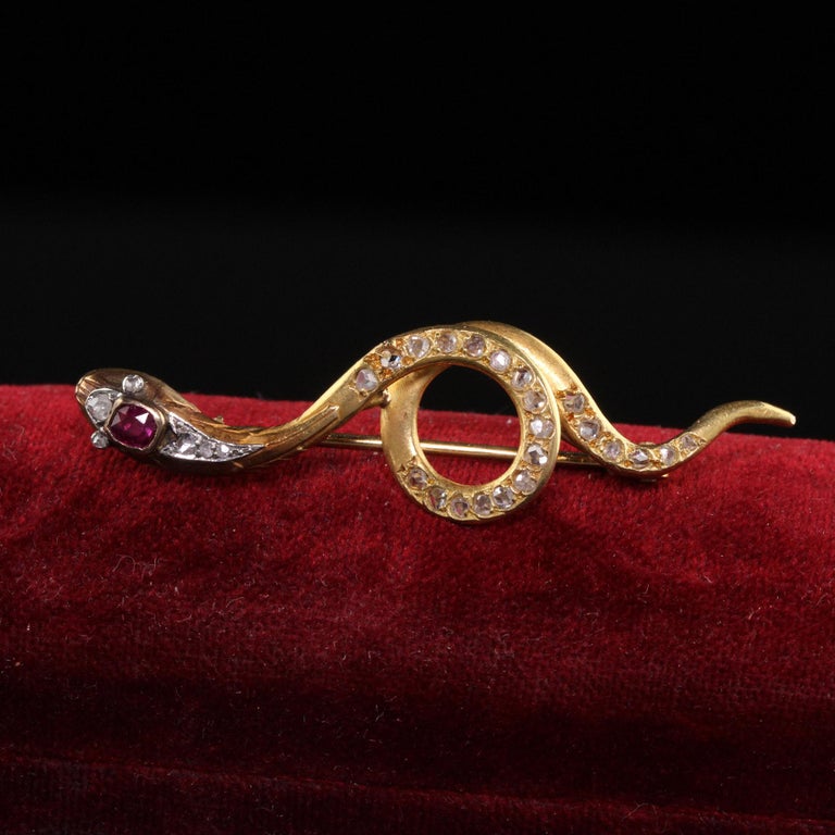 Beautiful Antique Victorian French 18K Yellow Gold Rose Cut Diamond and Ruby Snake Pin. This gorgeous snake pin is crafted in 18k yellow gold. There are rose cut diamonds going along the body and head of the snake and a natural red ruby on the head.