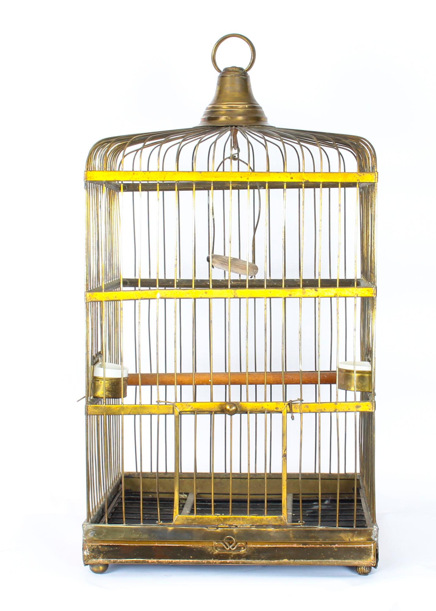 This is a very decorative antique French heavy brass parrot cage, circa 1880 in date.

The square shaped cage features fine brass wirework with a slightly domed top fitted with a central brass ring handle.

The interior has brass half round