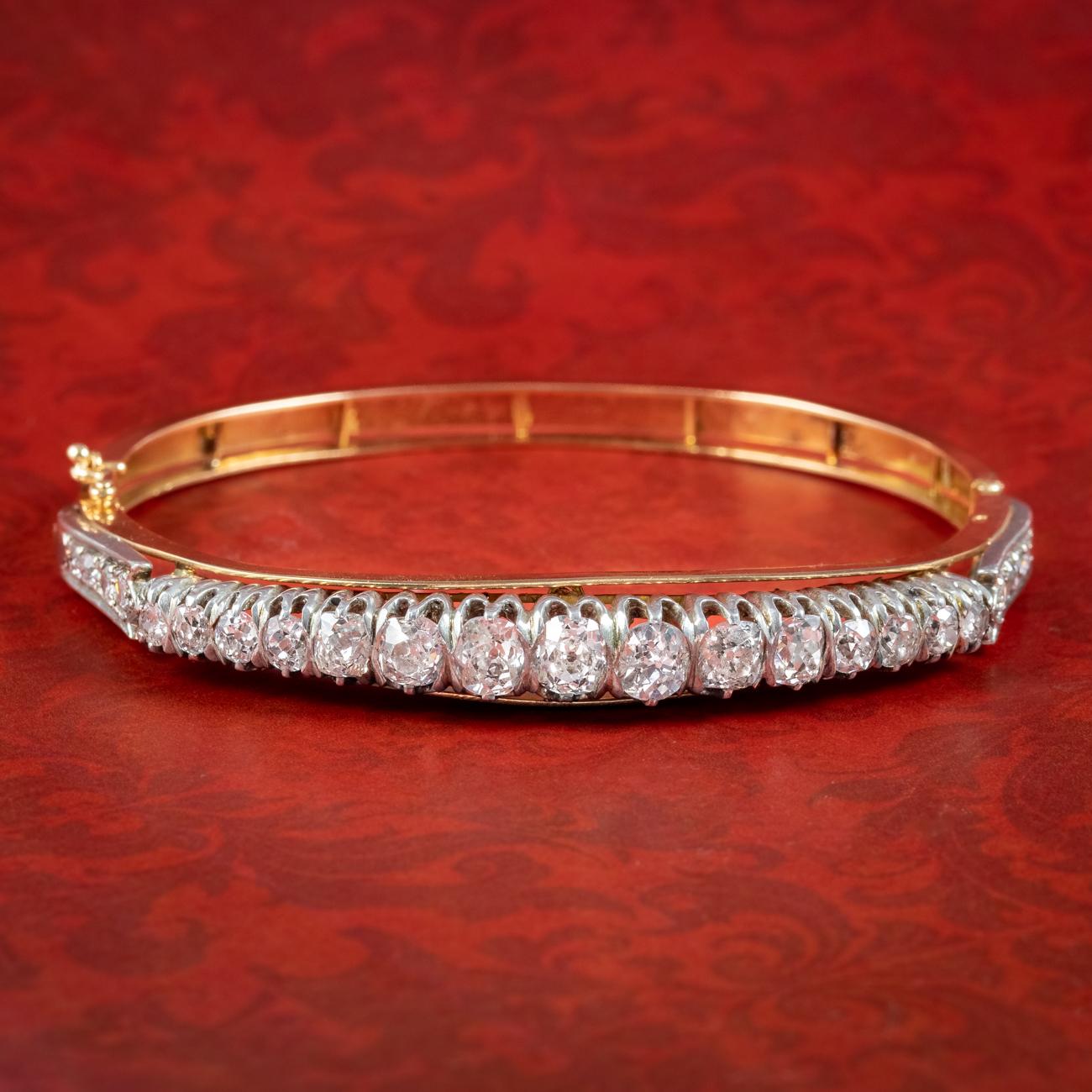 A magnificent antique French bangle from the late 19th Century lined with twenty-three old chunky cushion cut diamonds that graduate in size from 0.06ct stones on the shoulders to 0.50ct stones in the centre (approx. 4.5ct total). 


Diamonds are