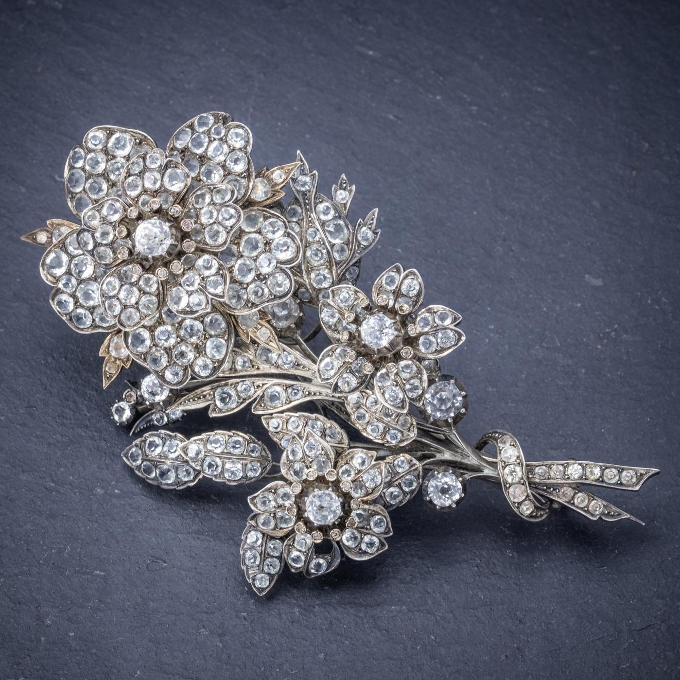 A spectacular antique French brooch from the early 20th Century depicting a bouquet of flowers decorated with old cut Paste Stones which simulate the sparkle and beauty of Diamonds. The brooch is expertly made with overlaid leaves and petals that