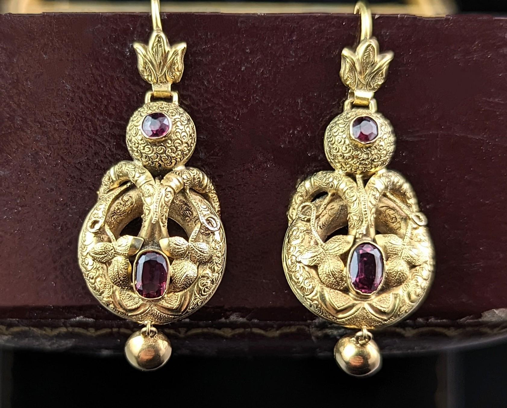 These antique Victorian garnet drop earrings are simply divine!

Such fine craftsmanship and attention to detail, they are crafted in rich 18ct yellow gold, door knocker style drops hinged from the top with a fantastic flaming grenade style.

The