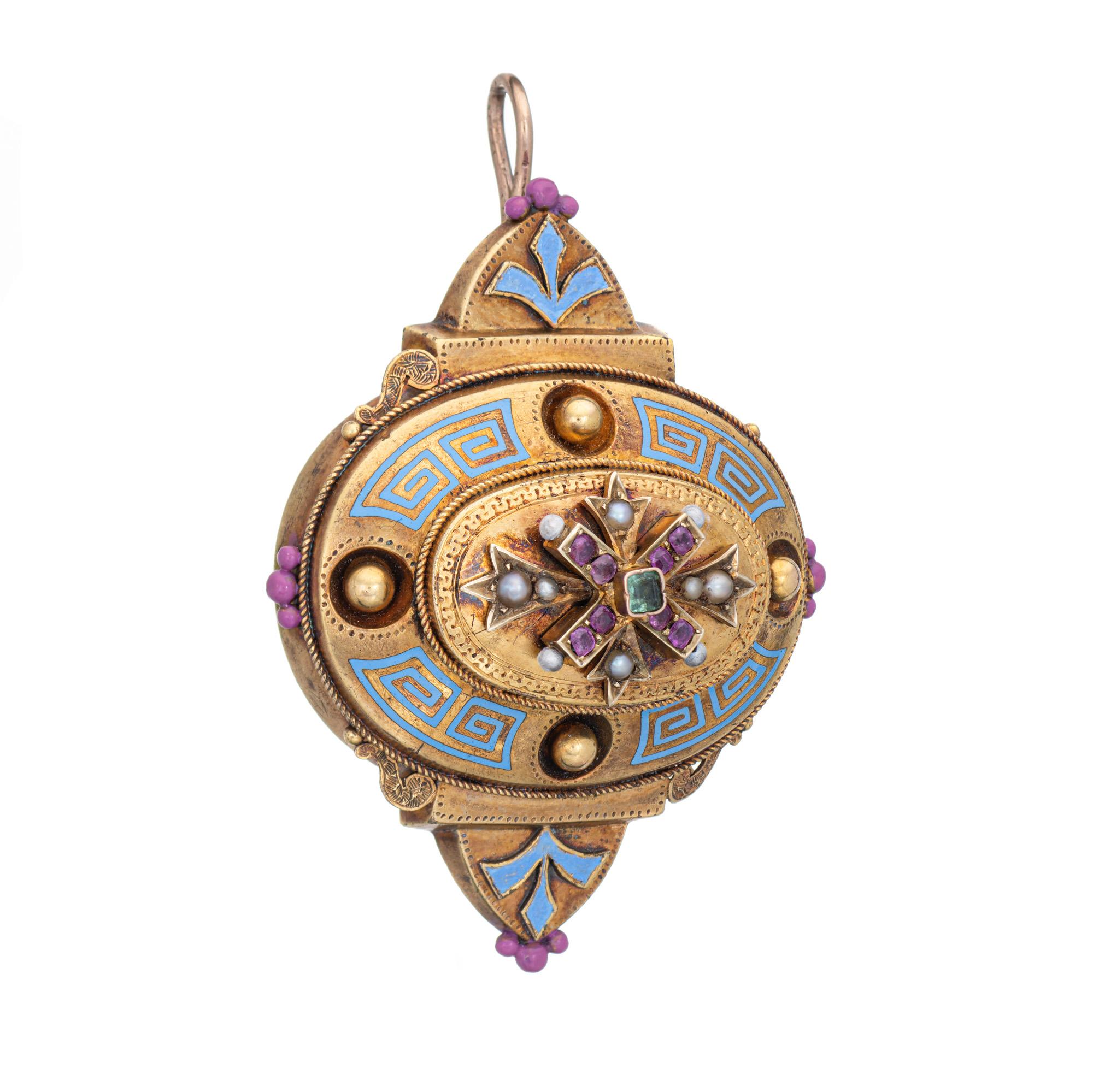 Pendente d'epoca vittoriano Etruscan Revival (circa 1860-1880) realizzato in oro giallo 14 carati. 

Piccoli rubini da 1,5 a 2 mm circa e uno smeraldo ornano la montatura. Piccole perle da 1 mm a 1,5 mm incorniciano la montatura.  

Il ciondolo,