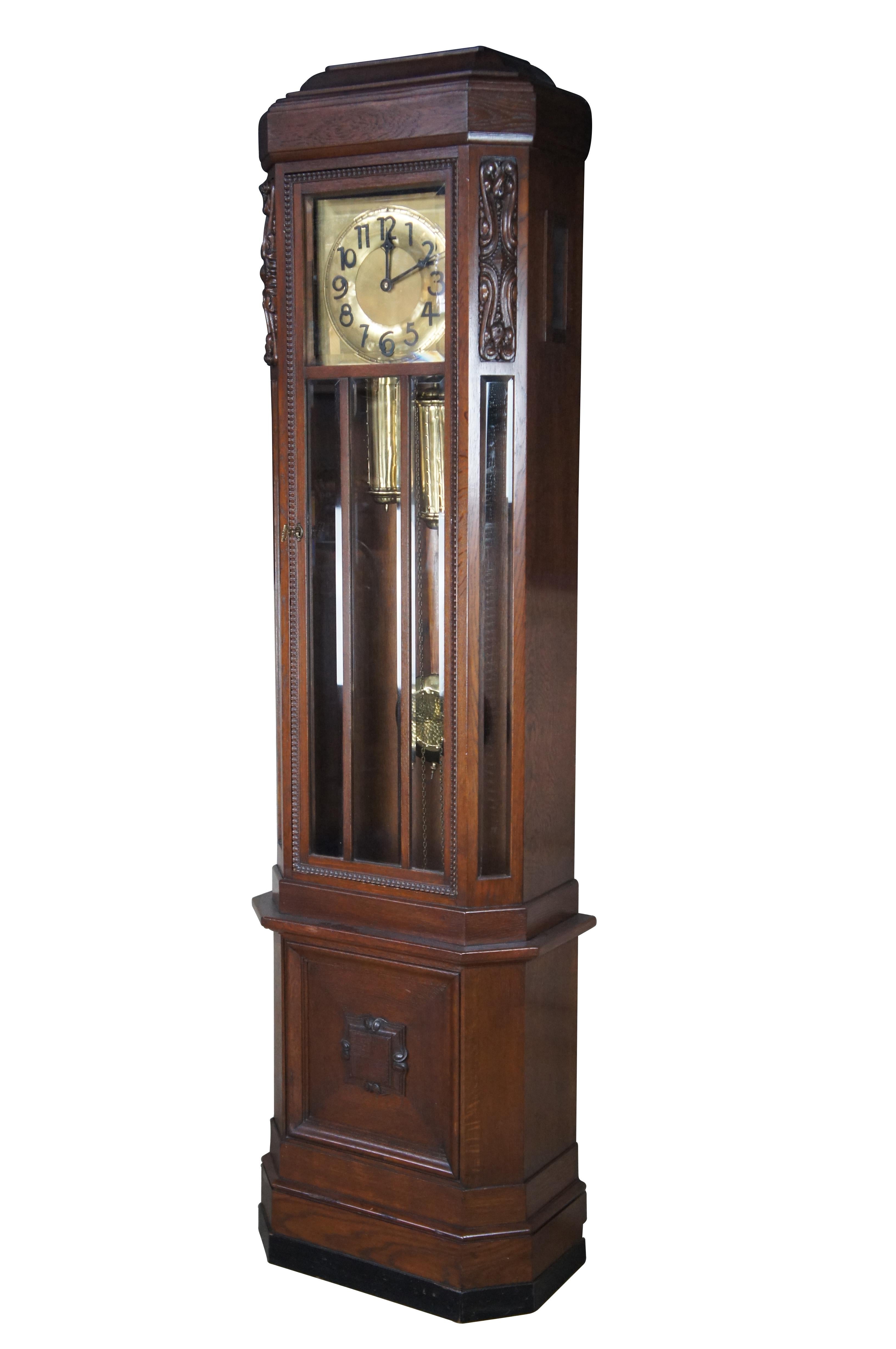 Antique Victorian German long case grandfather clock.  Made of oak featuring a faceted design with carved panels, beveled glass and brass face / weights / pendulum.

Dimensions:
24