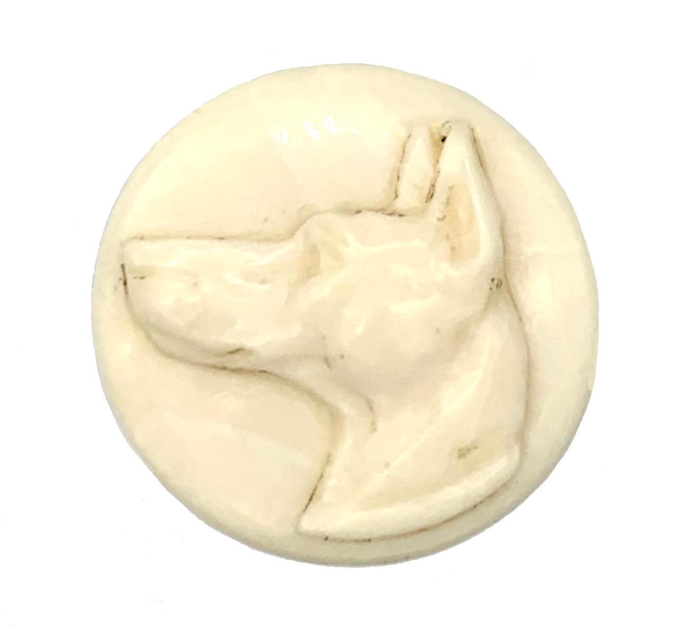 This substantiol desk top seal is carved out of bone and features  a german sheppered. the top is mounted in a brass fitting. the seal is engraved with the letters M M and with a griffin. 