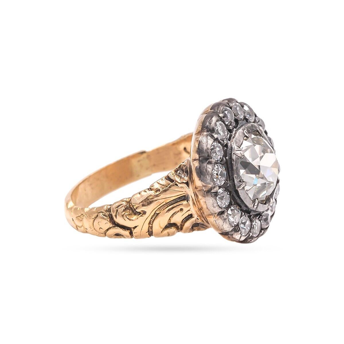 A superb example of a Victorian Era Cluster Ring. Composed of 15 Karat Yellow Gold & Silver. This Victorian era ring (circa 1860) features a center stone 2.17 Ct. Old Mine Cut Diamond. Surrounded by 16 Old European Cut Diamonds weighing 0.56 Ct. in
