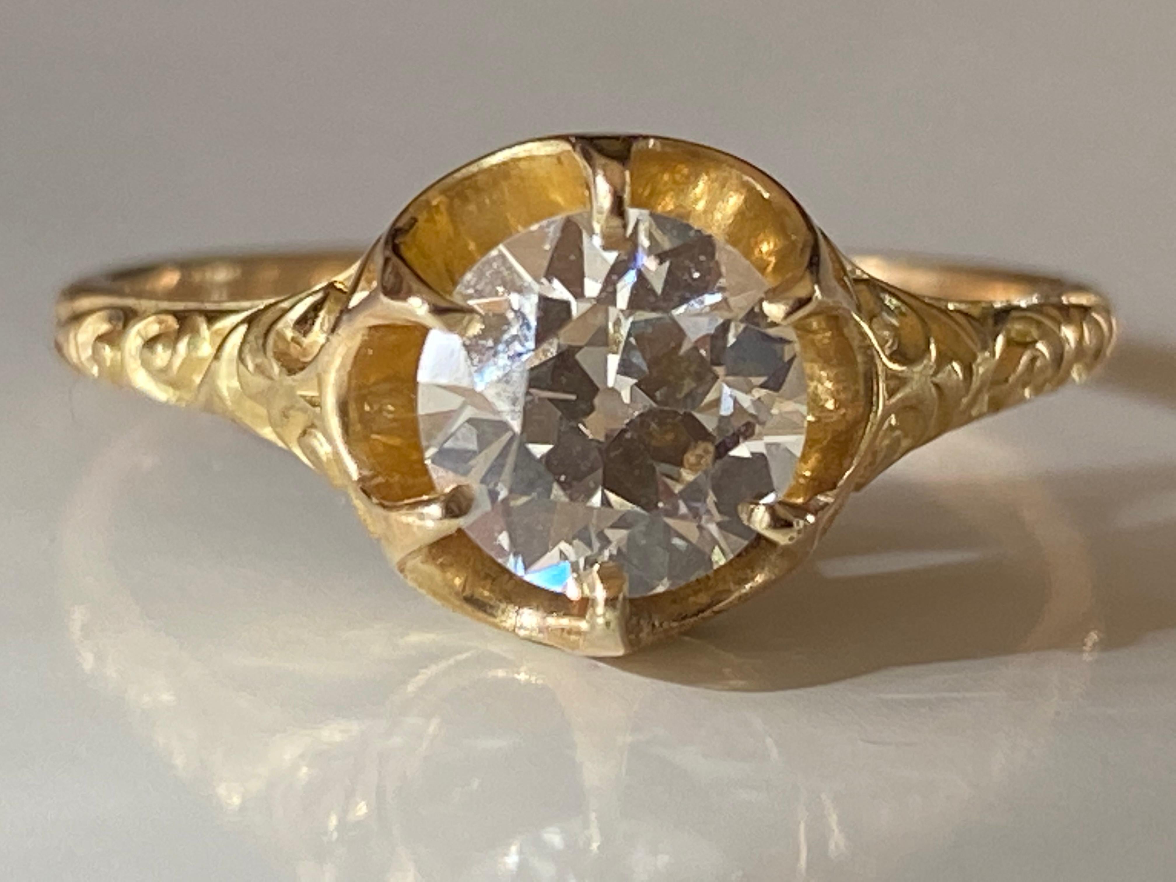 This shimmering GIA certified Old European cut diamond center stone measuring 1.01 carats, L color, VS1 clarity is held in a six prong claw setting on a delicate band handcrafted in 18kt yellow gold and adorned with delicate swirling engravings. 

