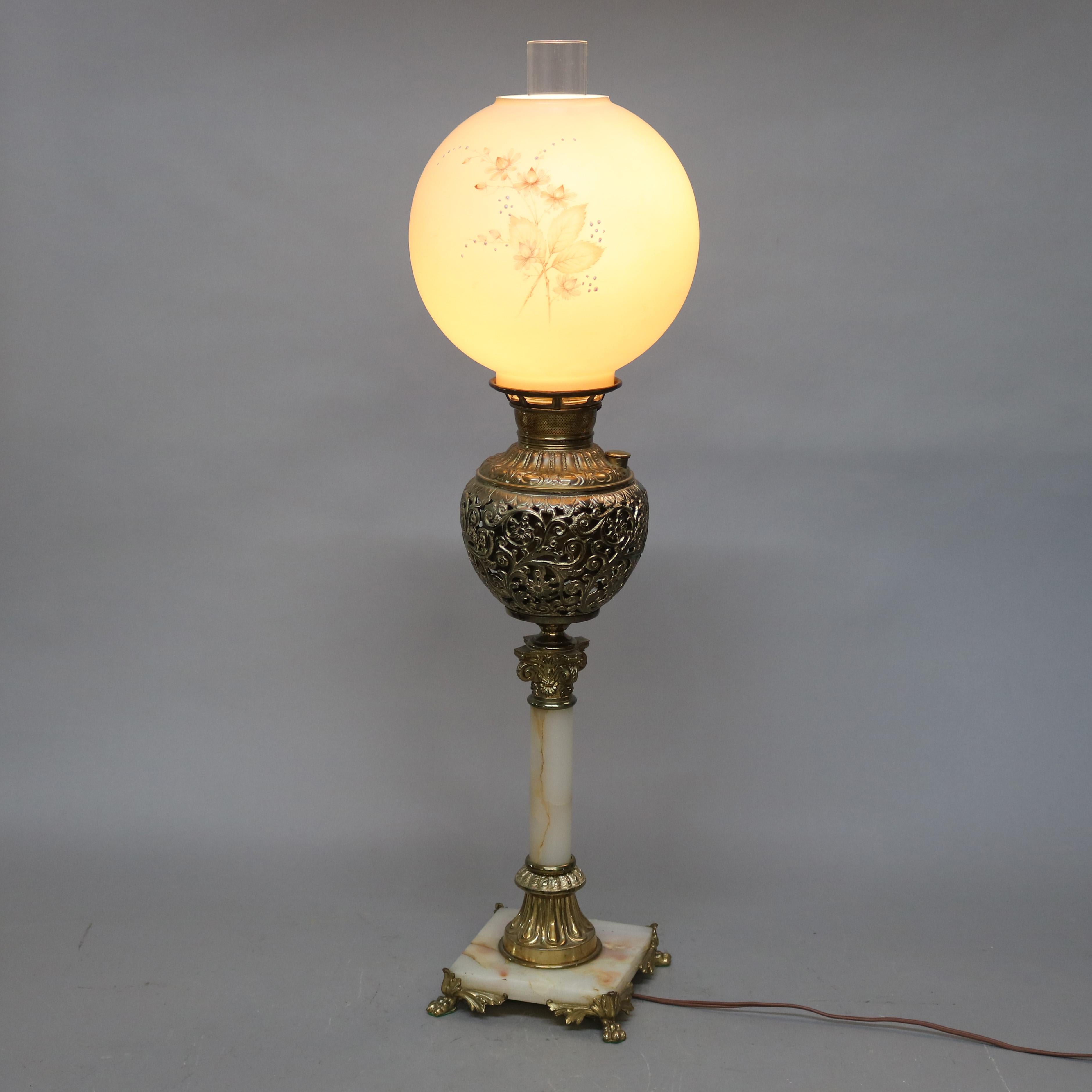 An antique Victorian parlor lamp offers floral painted shade surmounting gilt metal base with onyx column and footed base, circa 1890.

Measures - 33.25
