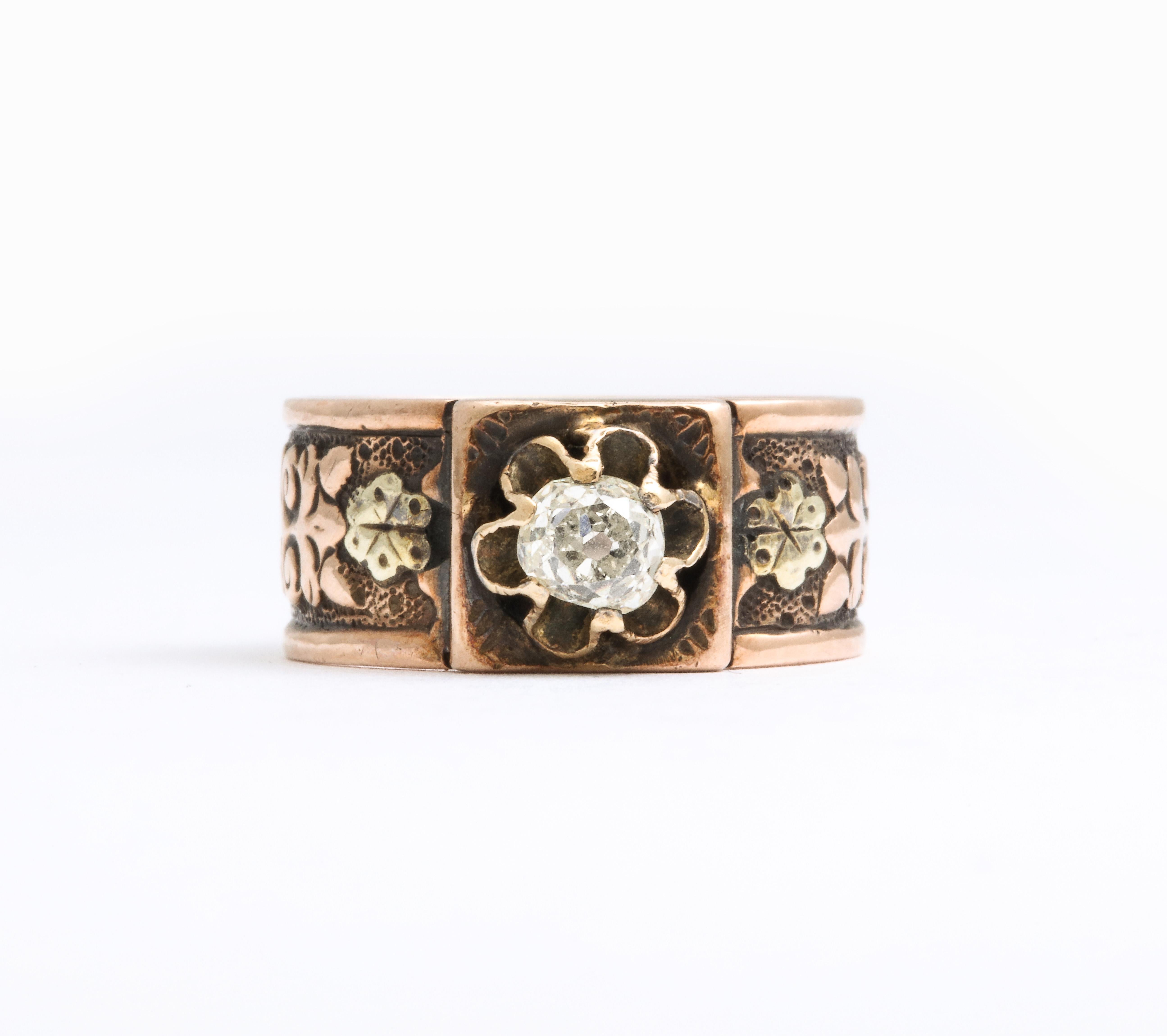 On a 14 Kt band with raised engraving of flowers and swirls, a .30 old European diamond is raised in a flower setting that is the focus of this ring. The borders are raised and unengraved. Texture is what stands out here. Emphasizing that texture,