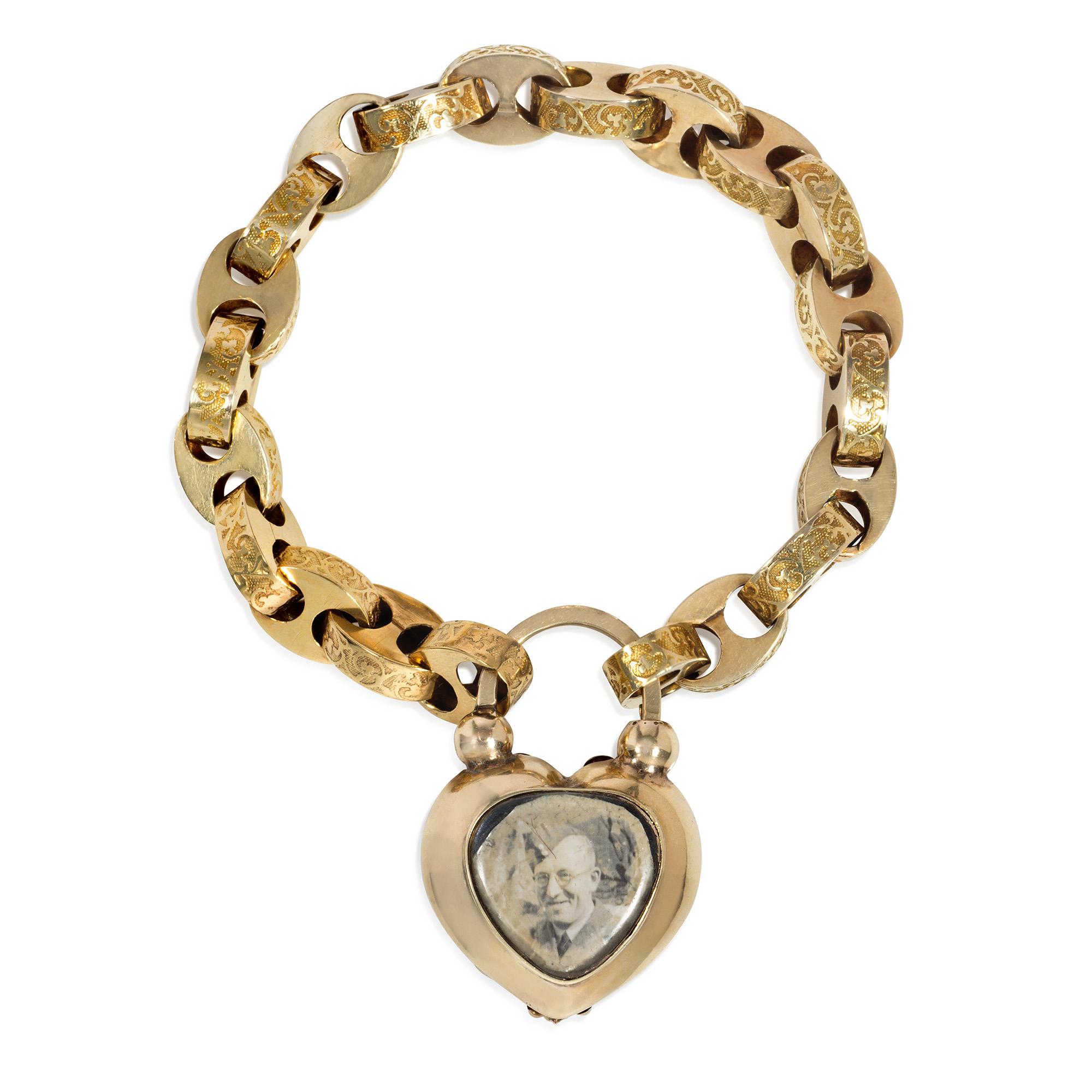 An antique early Victorian topaz and gold belcher link padlock bracelet, the finely chased links decorated with a clover-leaf rinceau over a stippled background, completed by a heart-shaped, locket-back padlock clasp centered by a faceted, ovoid