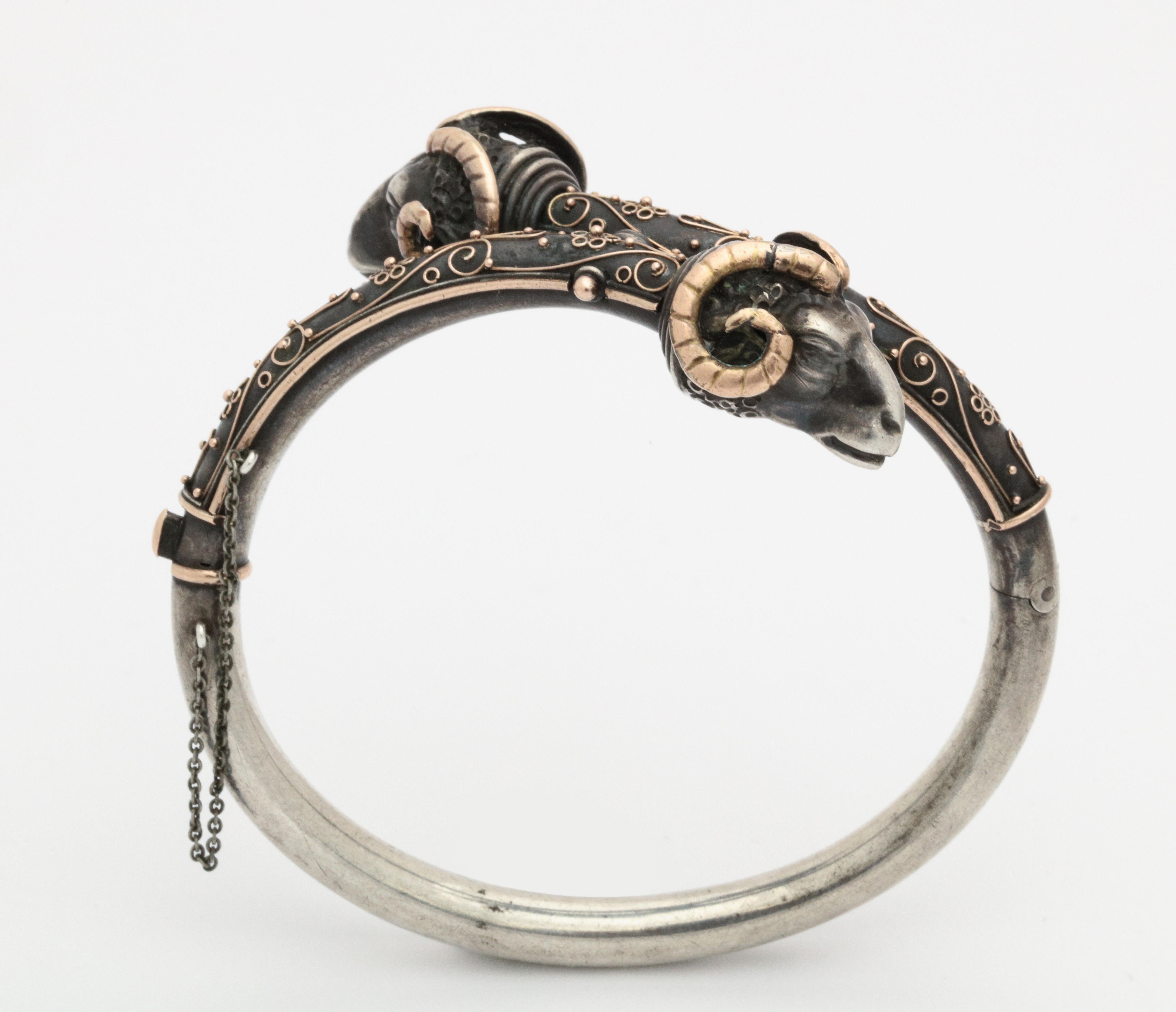 A 15 Kt gold and sterling refined jewel of a bracelet with double rams' heads and en rusted gold raised texture. The detail is the icing on the Ram. Certainly enlarge the photos to see the dimpled tufted coat, the striated gold horns and the strong