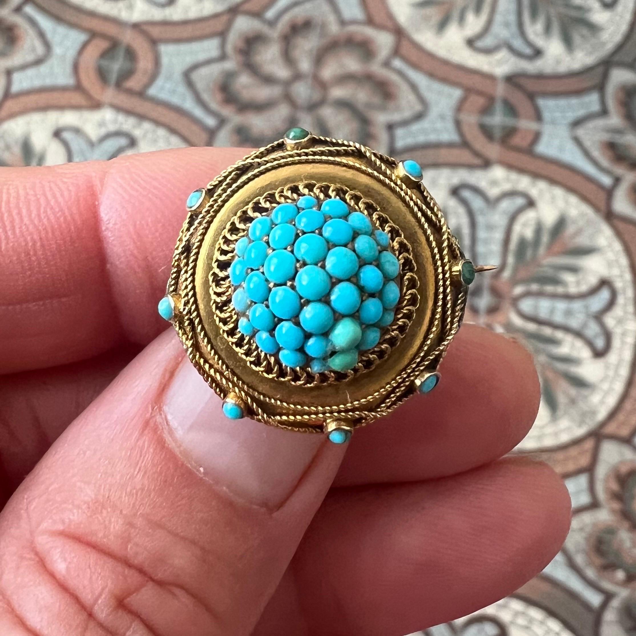 A beautiful late 19th-century brooch, finely crafted in 14 karat yellow gold and adorned with vibrant turquoise cabochons. At its center sits a domed cluster of round cabochon-cut turquoise stones, creating a bold, eye-catching focal point. The
