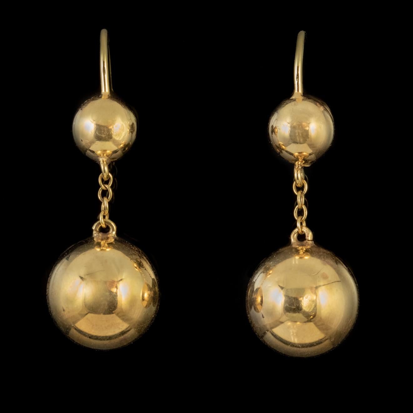 A glamorous pair of antique Gold drop earrings from the Victorian era consisting of two polished golden balls which are lovely and smooth on the surface and highly reflective. 

Each earring is modelled in 9ct Yellow Gold and suspended from chains