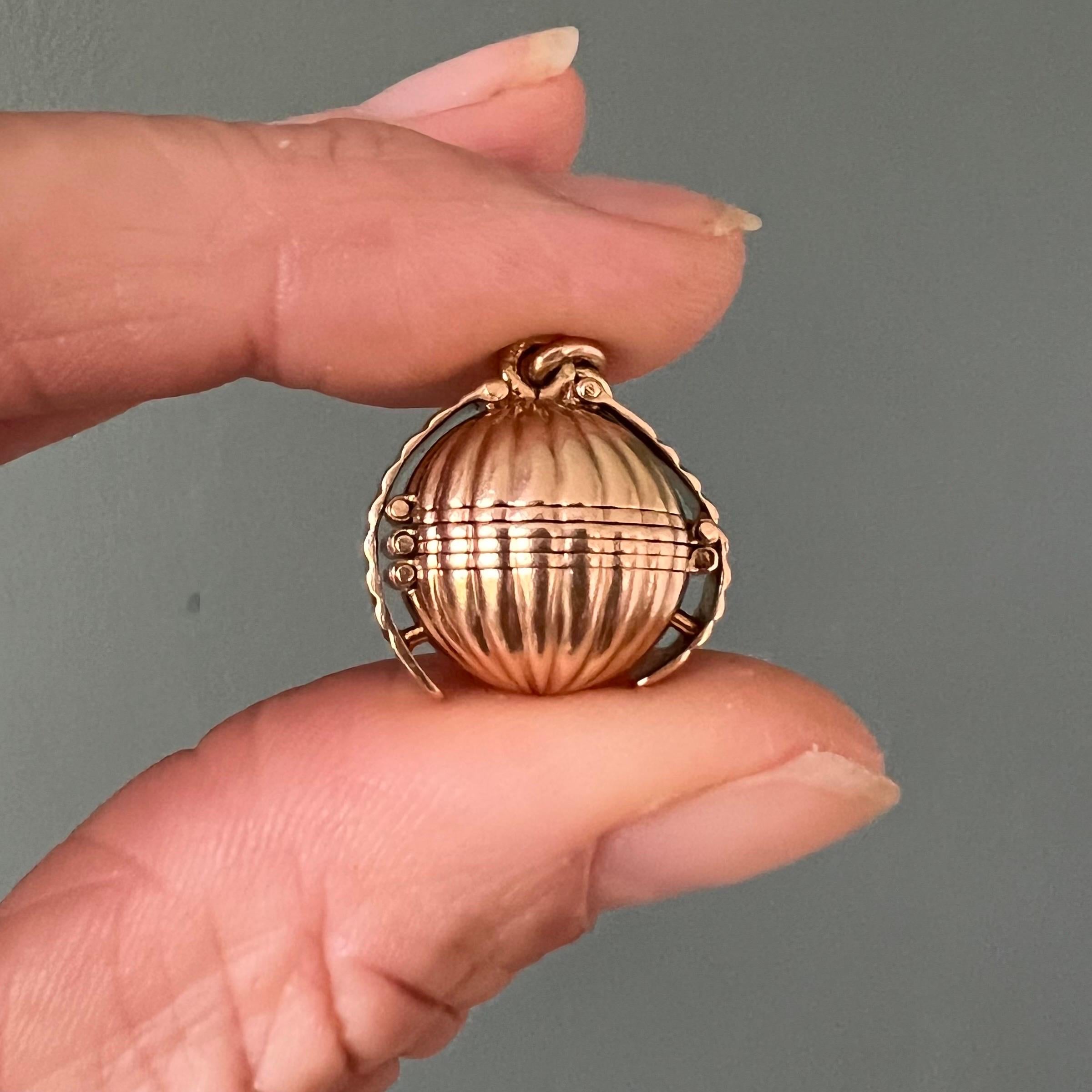 Ce magnifique pendentif pendentif boule pliable victorien antique est réalisé de main de maître en or massif 18 carats. Le design présente une forme sphérique nervurée qui se déploie élégamment en six compartiments ronds à charnière, révélant un