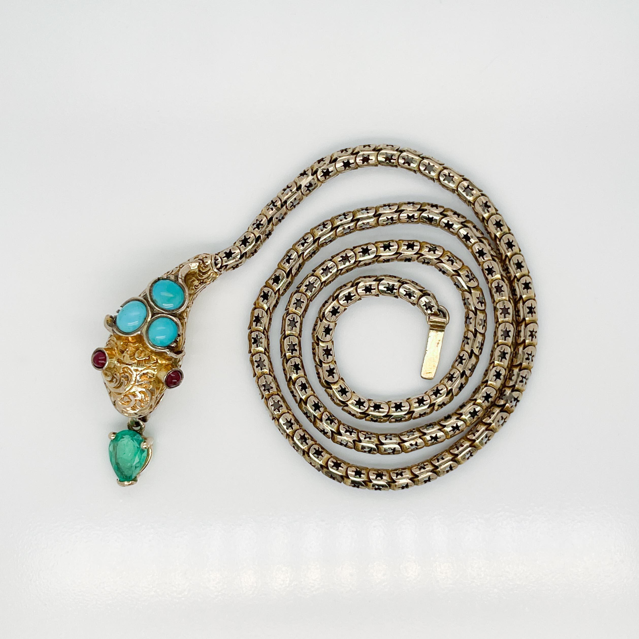 A fine Victorian gold snake choker necklace.

With smooth oval turquoise cabochons bezel set on top of snake head, round smooth garnet cabochons for the eyes, and a faceted pear shape emerald prong set in gold that dangles from the mouth. 

The