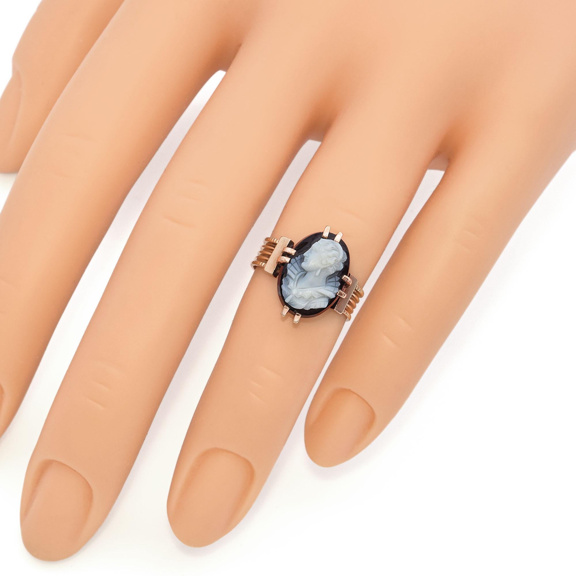 This exquisite ring features a finely detailed cameo set in a rose gold band. The cameo depicts a classical profile, intricately carved with precision. The gold setting enhances the elegance of the piece, with prongs securing the cameo in place. The