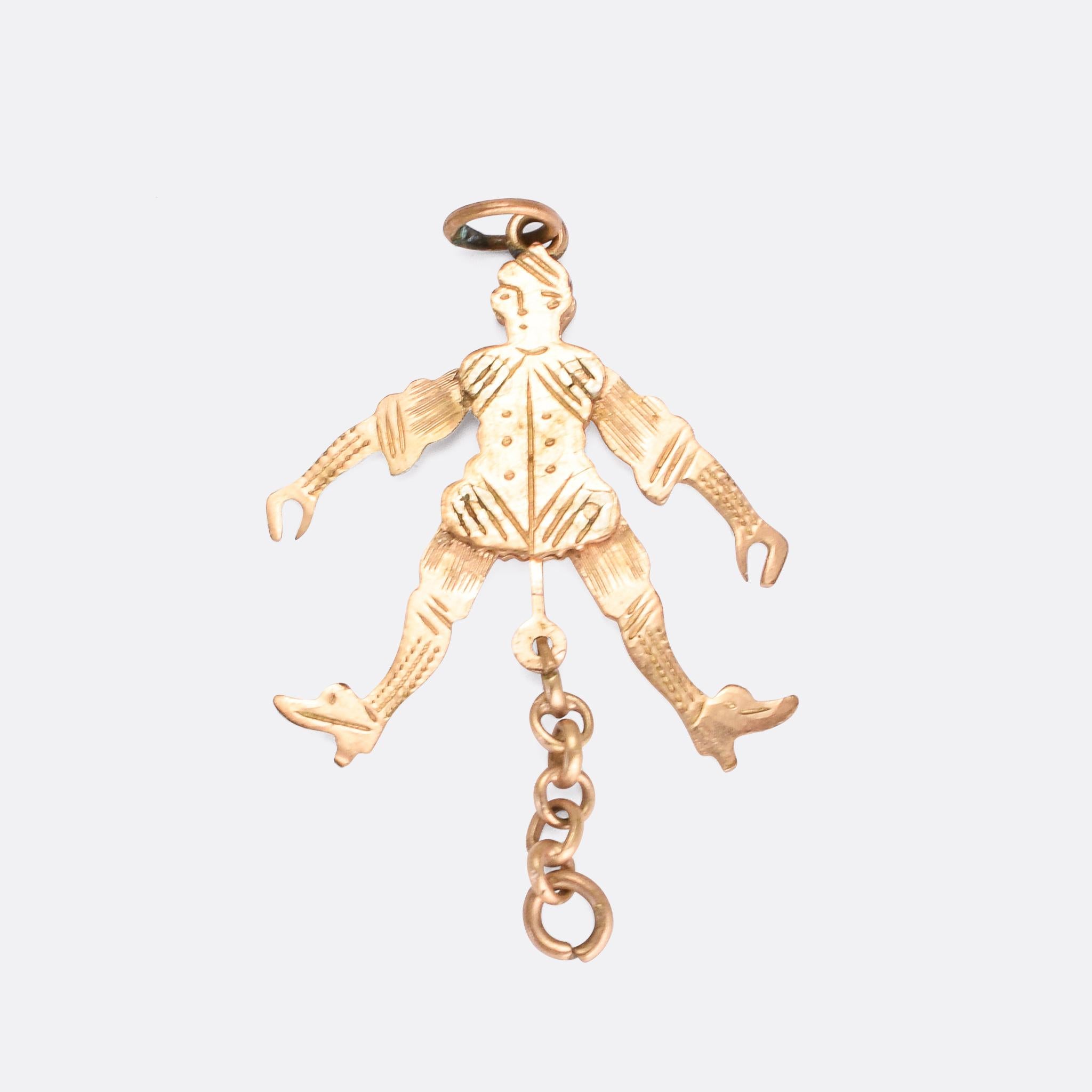 A cute antique novelty pendant modelled as a jester. The piece is articulated: when the chain at the bottom is pulled, the arms shoot up and the legs kick out. It's crafted in 9k gold and features hand-chased detaling to the face and