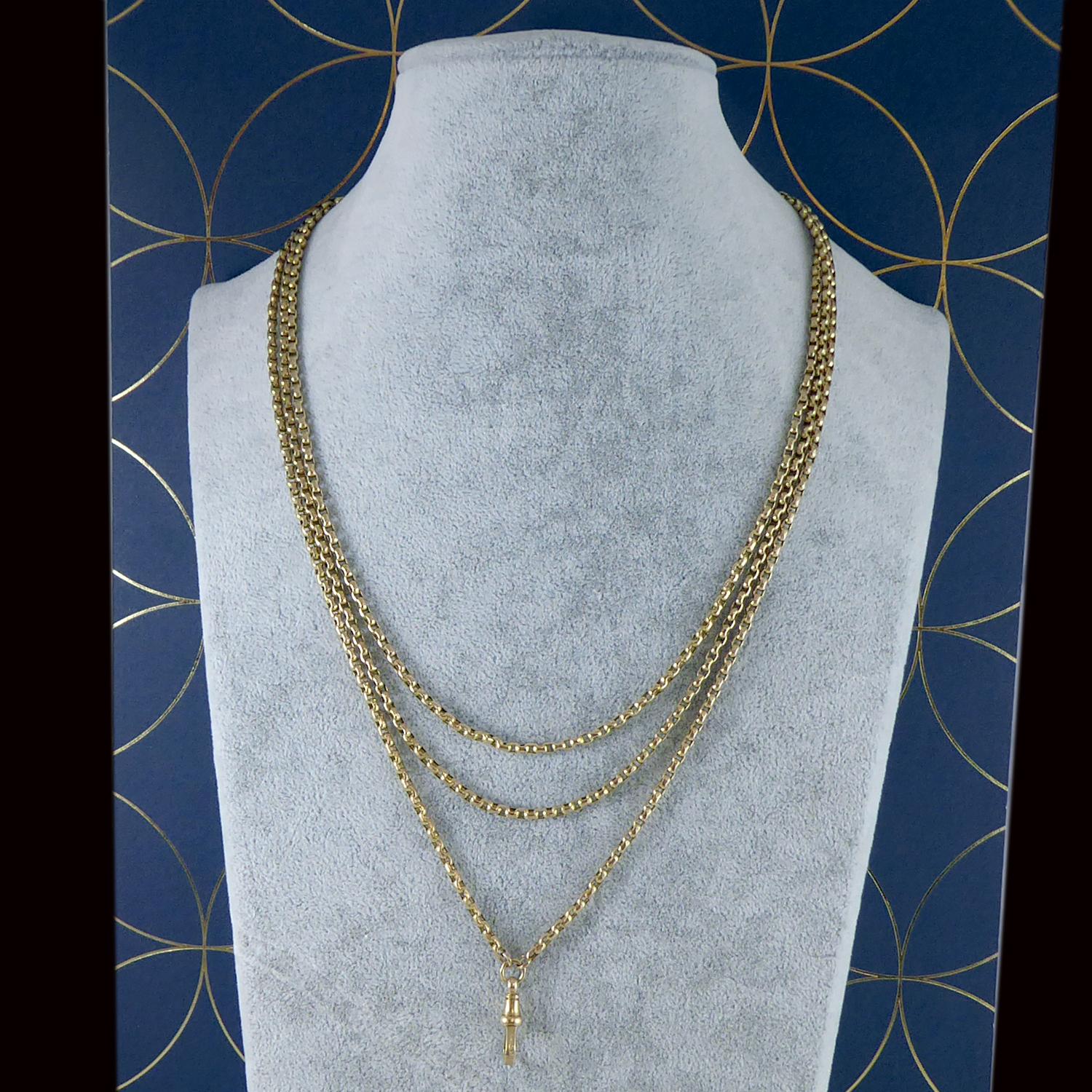 An antique gold long watch chain from the Victorian era.  Comprising small, oval faceted, belcher links in 9ct yellow gold.  The chain measures approx. 61 inches long and is fitted with a swivel clip at the centre point to which pendants of your
