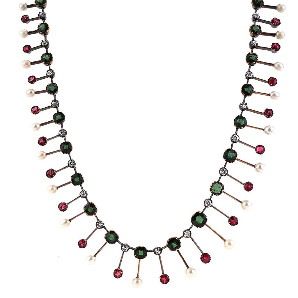 This Marshall Field & Company Antique Victorian necklace is made of 8K yellow gold and weighs 18.90 DWT (approx. 29.4 grams). It contains 36 single cut diamonds, 36 cushion cut green tourmalines, 36 round cut red spinels, and 47 white freshwater