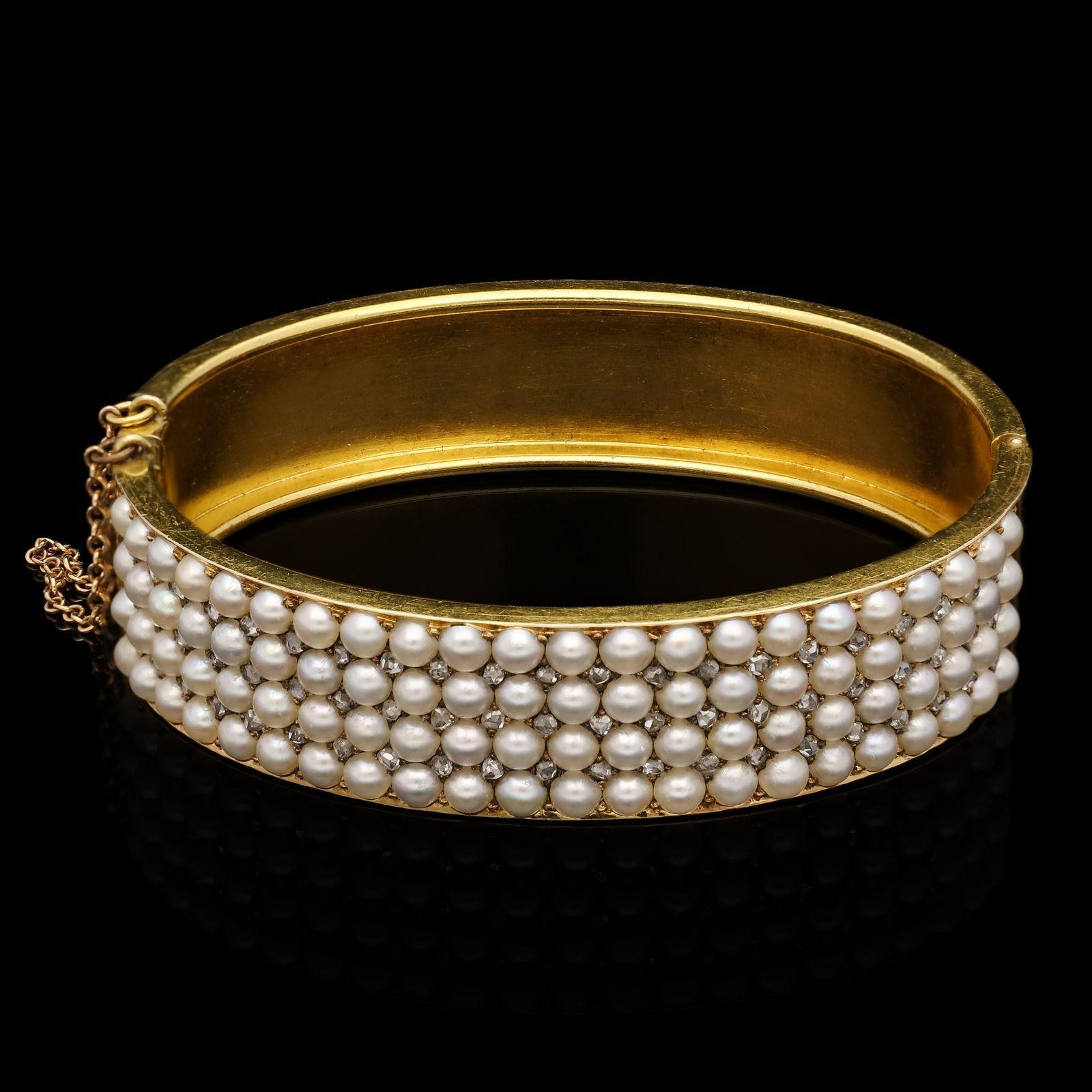 A Victorian gold, pearl and diamond bangle c.1880s, the solid bangle in 15ct yellow gold with hinged side opening, set throughout the front with four straight uniform rows of creamy-white round half-pearls all interspersed with rose diamond points,