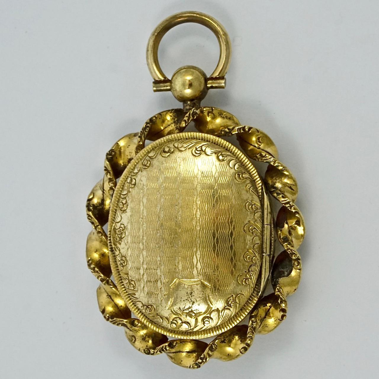 Antique Victorian gold plated locket with a twisted edging, featuring lovely hand engraved swirl and line designs on both sides. The locket is held loosely within the edging. Measuring length 3.8cm / 1.5 inches by width 3.2cm / 1.26 inches. There is