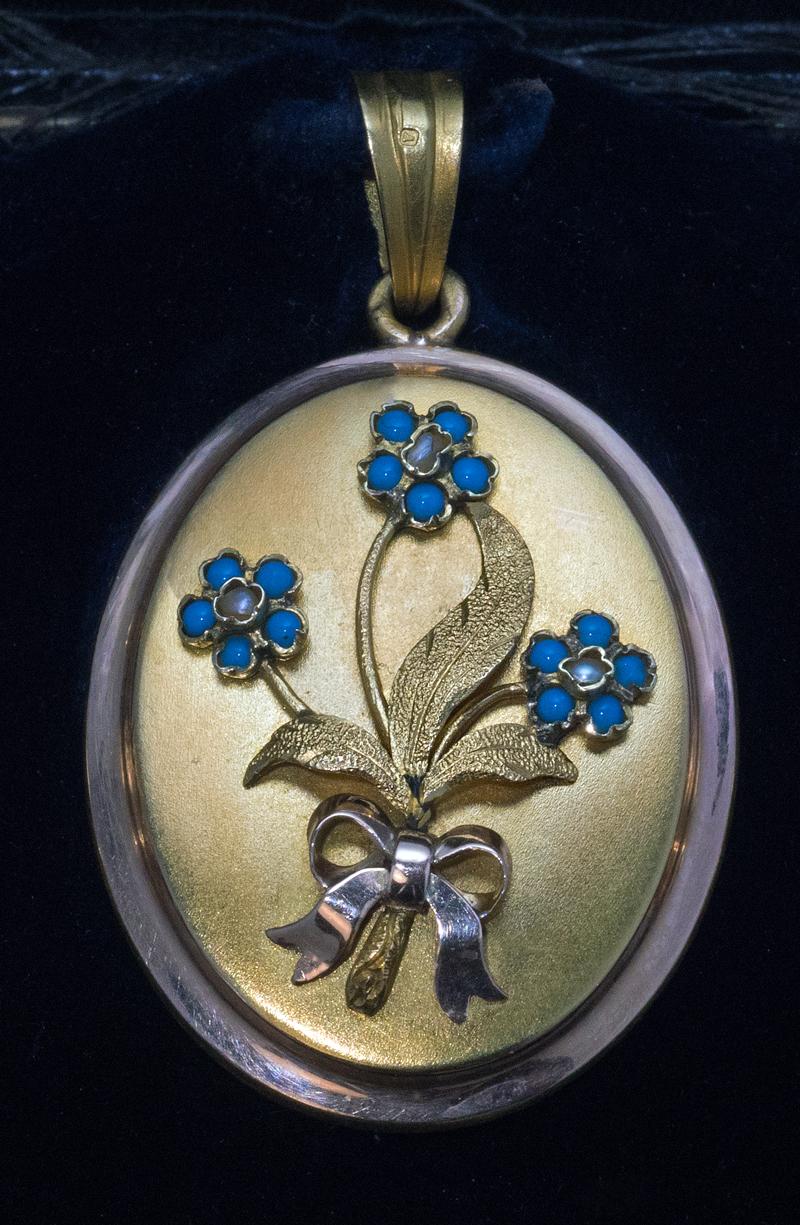 Vienna, Austria, circa 1875

This is a mid-Victorian era matte 14K gold set comprising a pendant locket and a pair of earrings, both embellished with turquoise and pearl forget-me-not flowers. The interior of the locket is set with two glazed