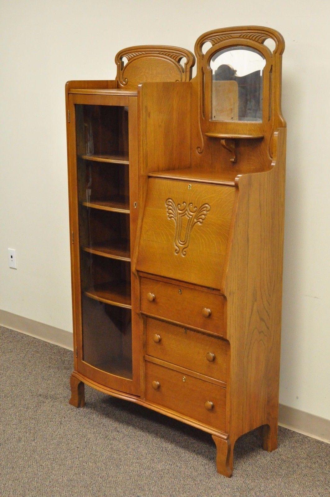 Antique Victorian Quartersawn golden oak bow glass side by side bookcase / secretary desk. Item features bow glass door, adjustable shelves, beveled glass mirror, drop front surface, fine carvings, beautiful golden oakwood grain, and working locks