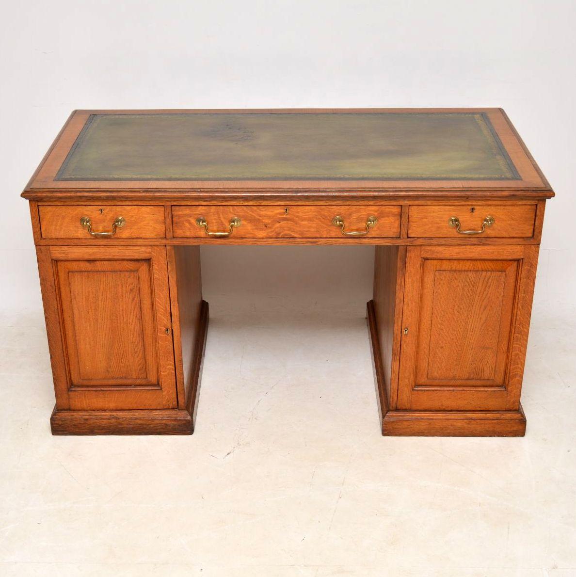 This antique Victorian pedestal desk is solid oak and is designed a bit different from the usual model. It has a lovely golden oak color and is in excellent condition having just been polished. The leather writing surface is hand coloured with a