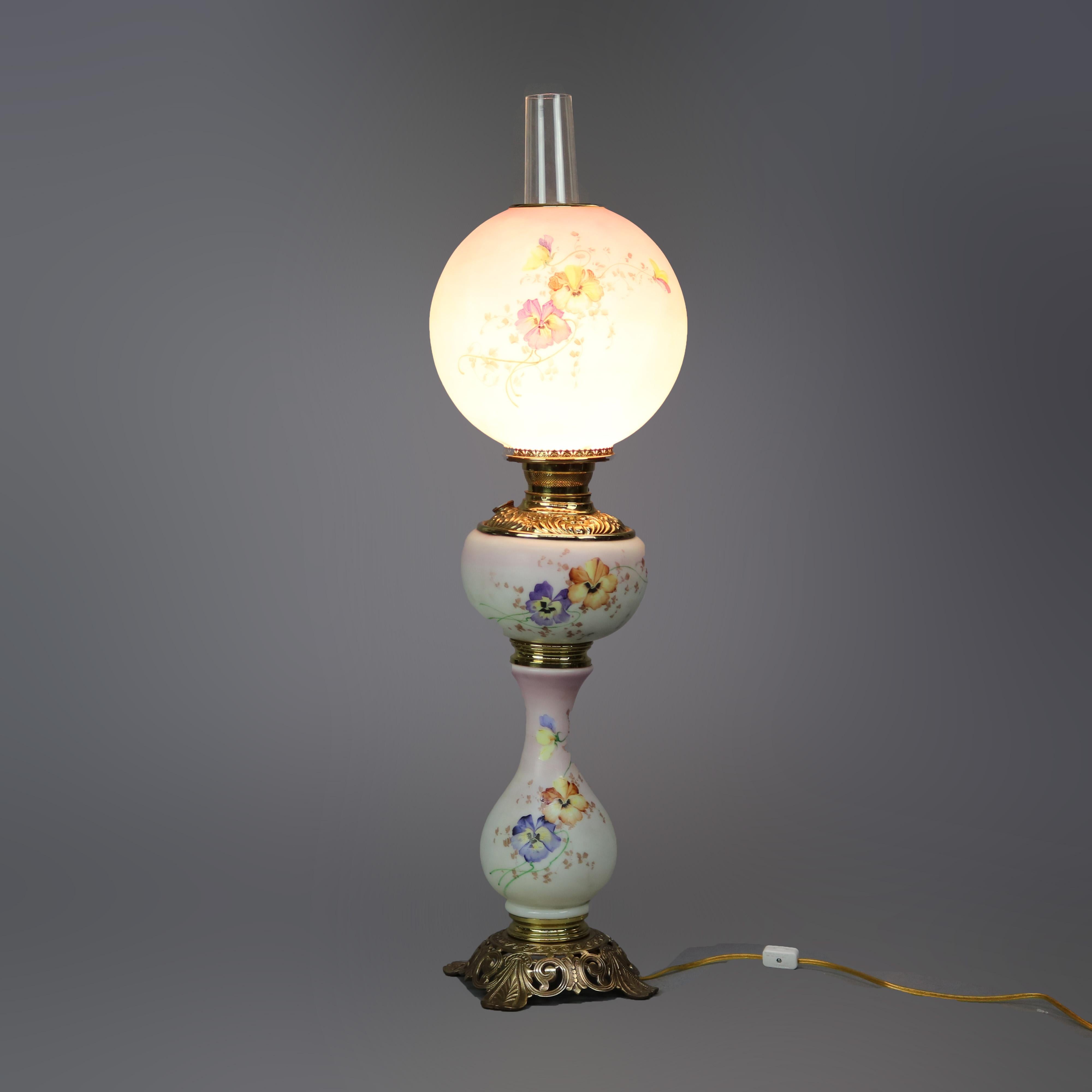 Antique Victorian gone with the wind parlor table lamp offers floral hand painted glass and brass construction in hourglass form seated on cast foliate base, electrified, c1890

Measures - 33.5'' height x 8.5'' diameter.