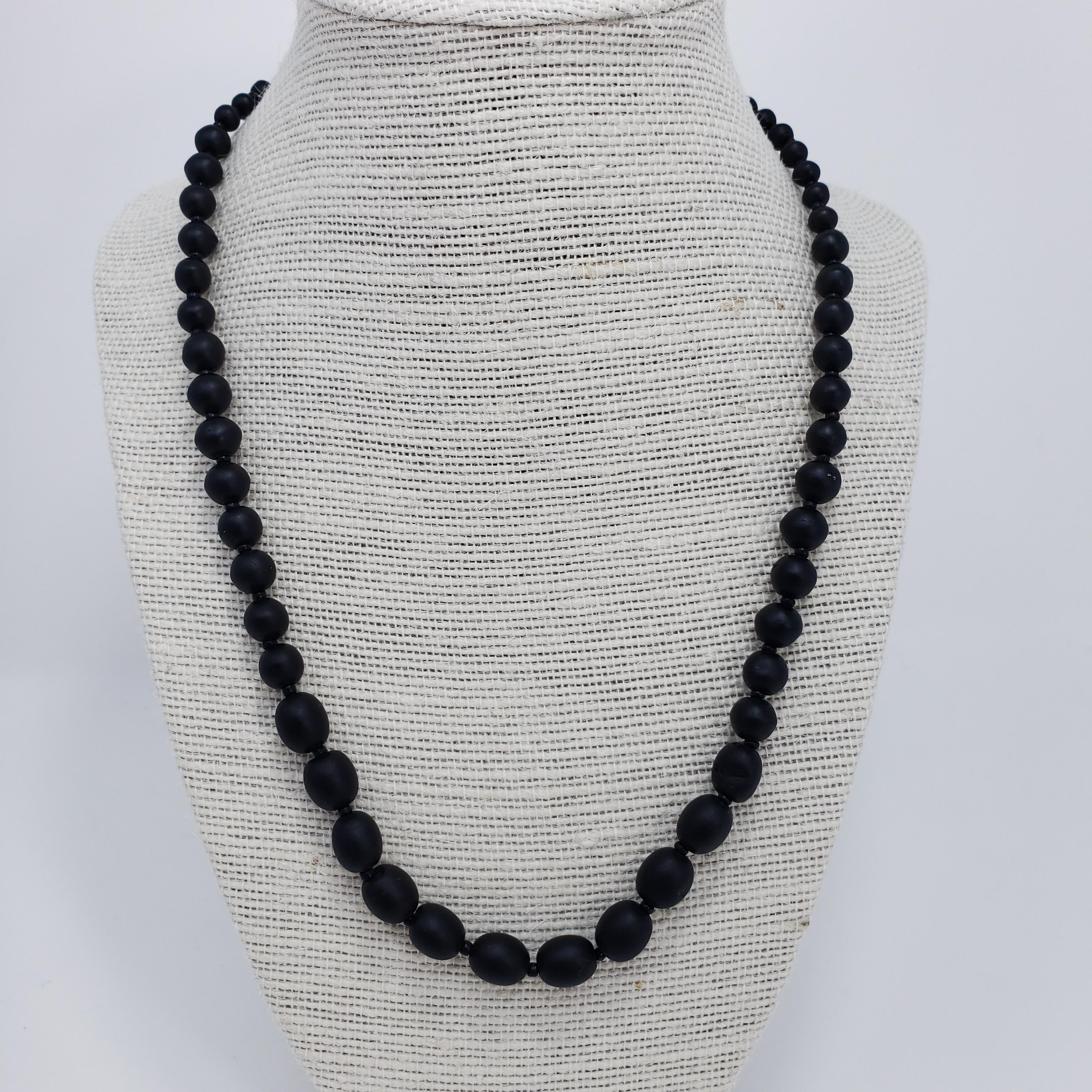 A remarkable Victorian mourning necklace. Graduated jet beads, varying in size from 4x3mm to 10x8mm, hang on a black string, separated with small jet circlets. 51 cm in length, with spring ring clasp closure.

Has light wear and minor repairs