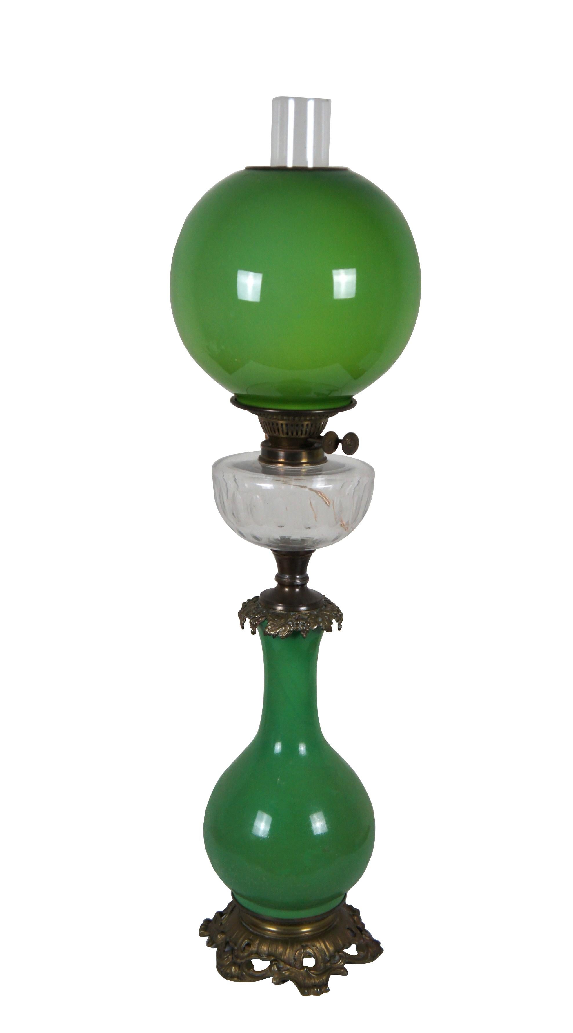 Rare apple green antique Victorian parlor Gone with the Wind oil lamp converted to electric. Foliate brass base with vase shaped green glass body, topped with grape vines; clear thumbprint reservoir and hurricane, Duplex - Made in England burner,