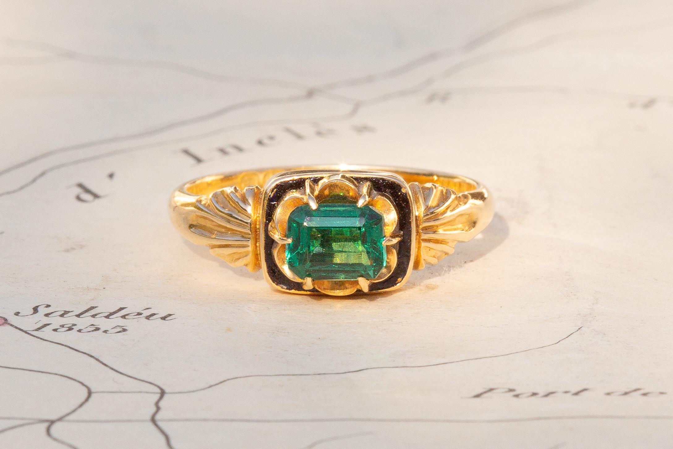 This striking antique single-stone ring was made in London and dates to 1890. It is crafted in 18K gold and set with an octagonal step cut green paste in a pronged setting. The stone is a wonderful vivid green colour and sits majestically in the