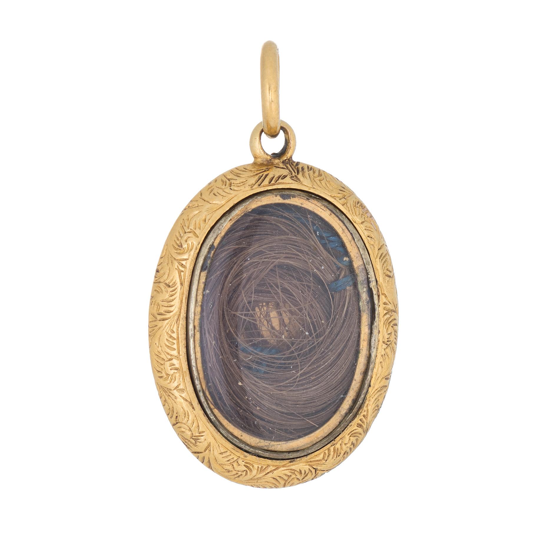 Finely detailed Victorian pendant (circa 1880s to 1900s) crafted in 18 karat yellow gold. 

The oval pendant is fitted with a lock of hair behind a protective plastic case (does not open). The reverse side features an intricate decorative foliate