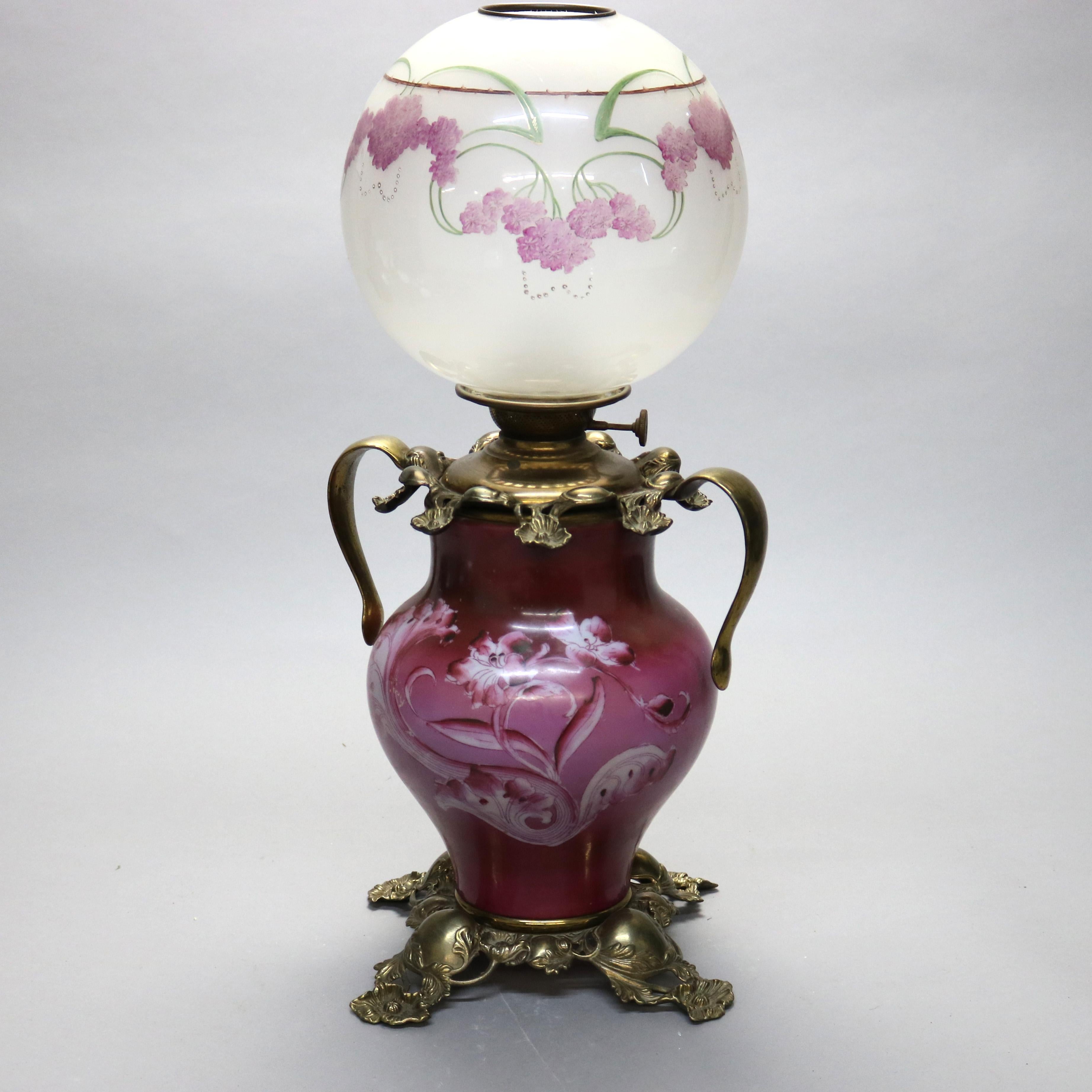 An antique Victorian kerosene table lamp offers floral hand painted glass globe and font in double handled foliate cast frame, not electrified, c1890

Measures - 25.5'' H x 13.5'' W x 13.5'' D.