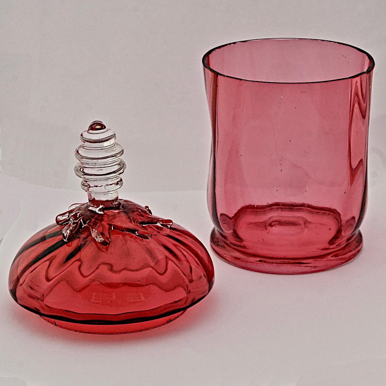 Merveilleuse jarre victorienne ancienne en verre canneberge faite à la main, avec un couvercle en verre transparent appliqué. La hauteur est d'environ 17 cm / 6,7 pouces, et le diamètre de la base est de 7,8 cm / 3 pouces. Il y a une marque de